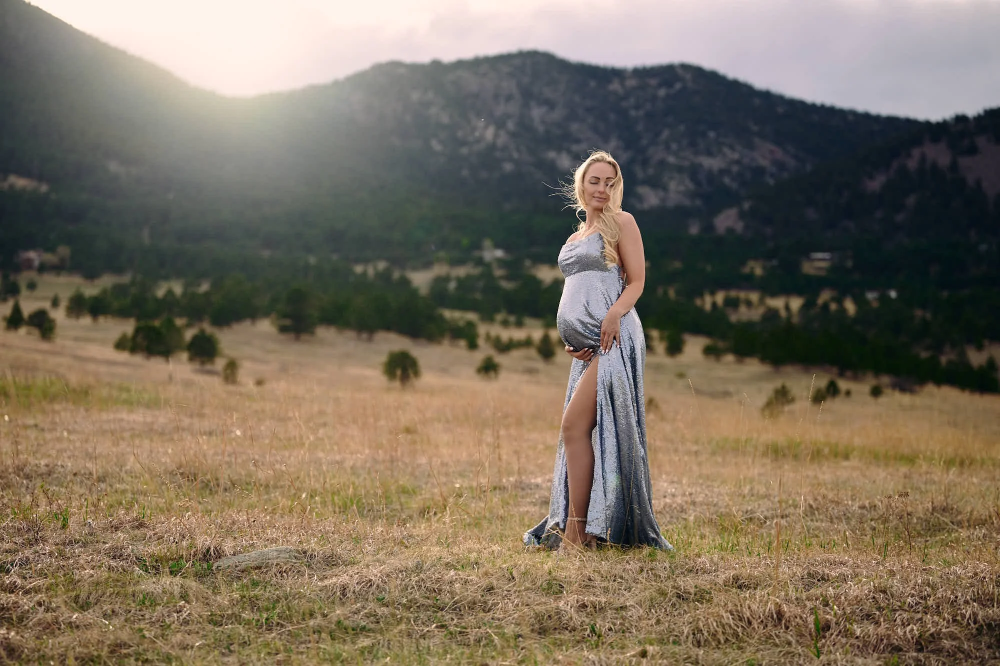 Silver gown with a high slit in a dusky field, the last light burning behind the ridge, by Ethan Herrold.
