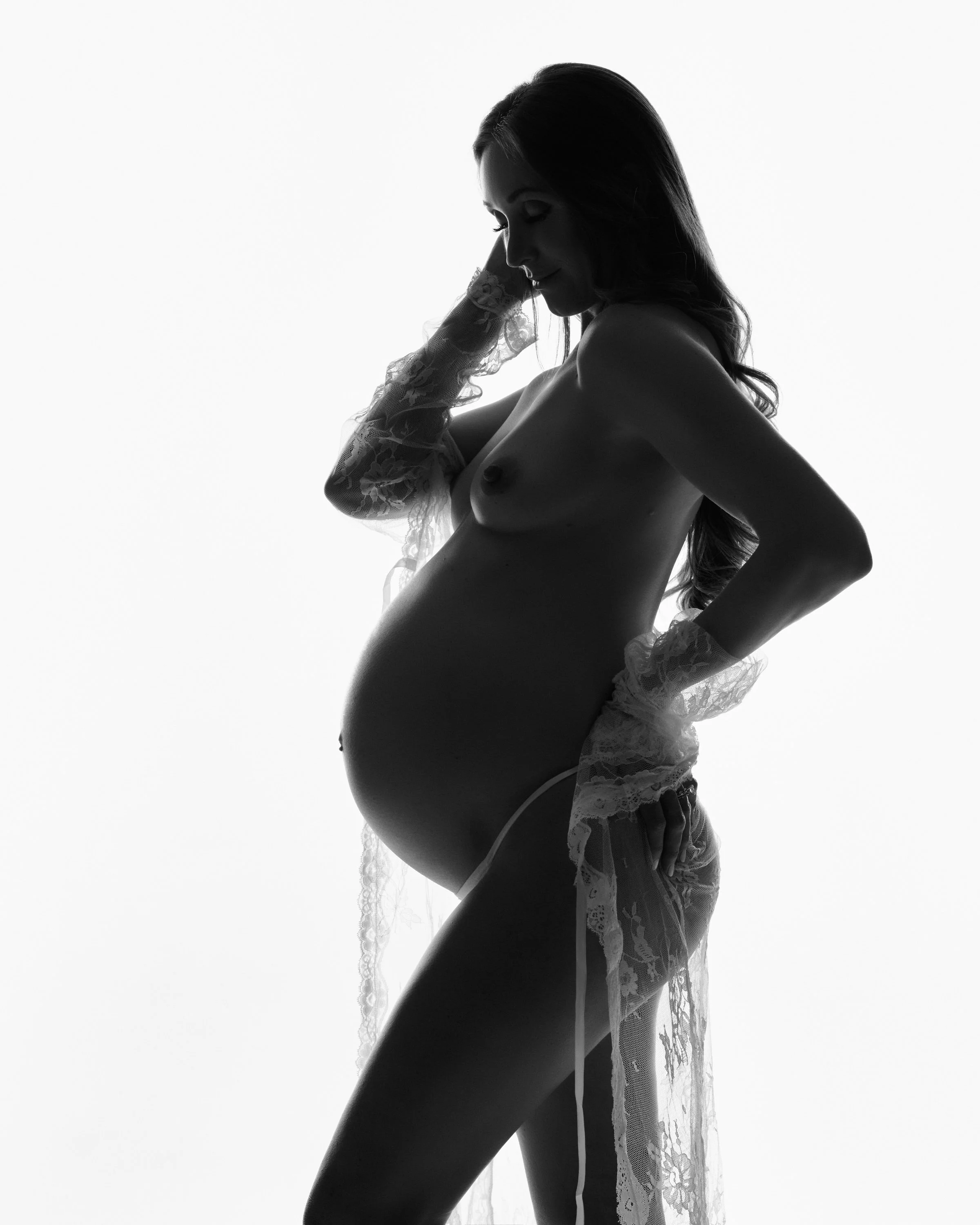 Backlit sheer fabric in a bright doorway of light, profile in silhouette.