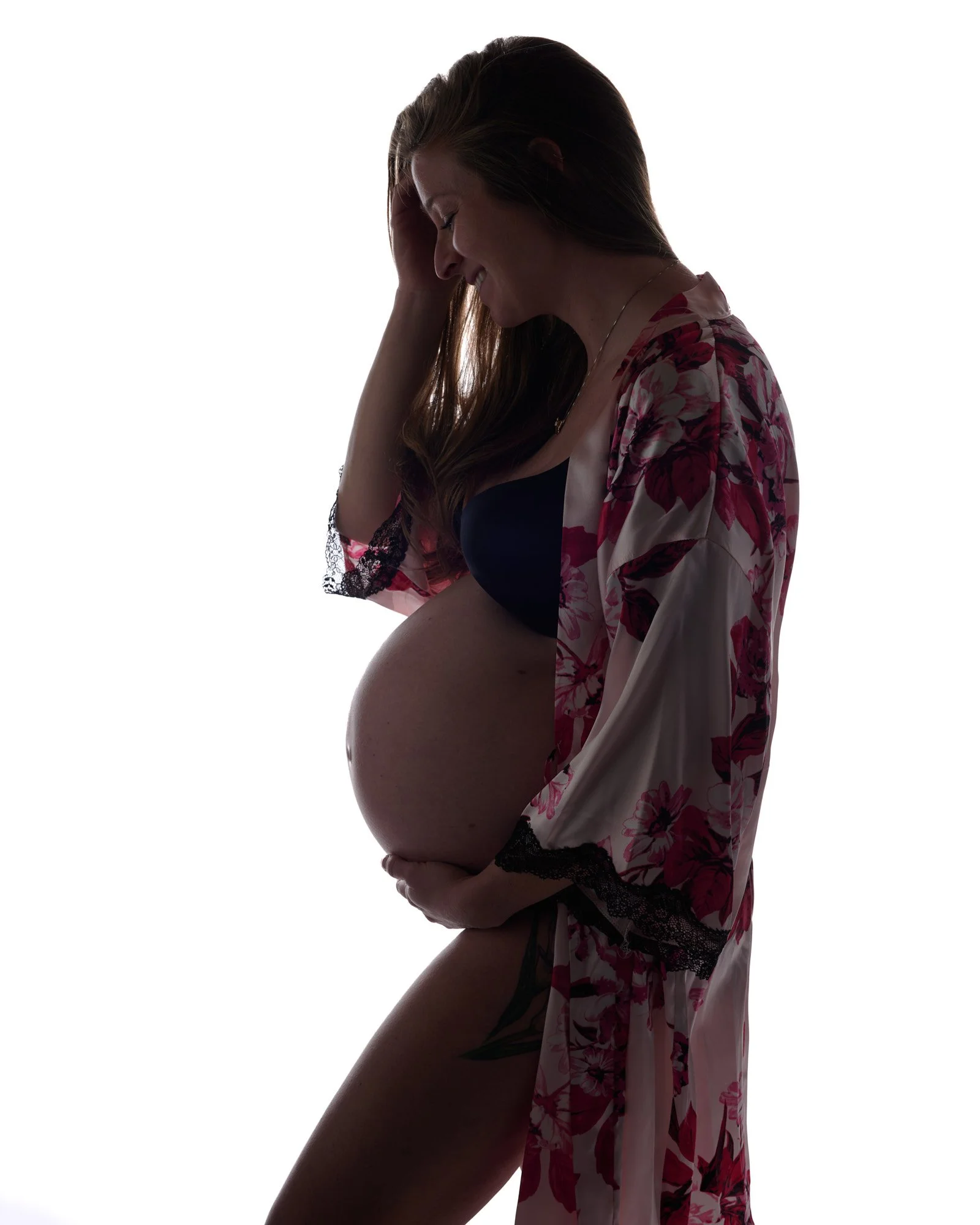 Floral robe slipping off one shoulder in moody window-style light.