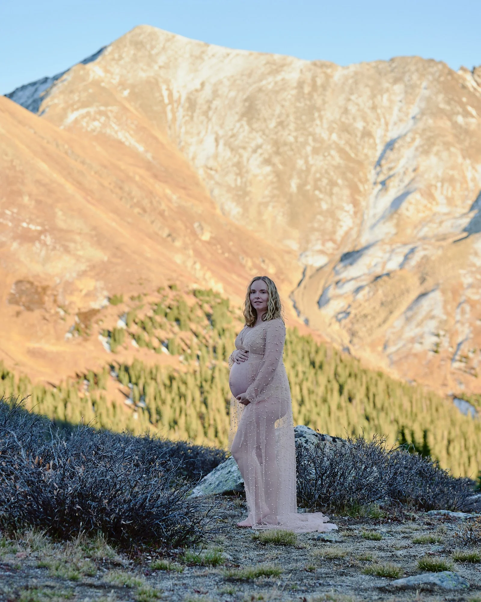 Expecting mother in a lilac gown on an alpine mountainside on Loveland pass near Denver, from the Colorado location guide.