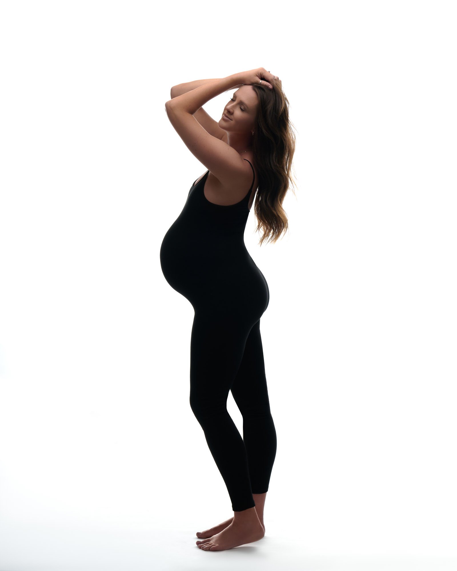 Sleek studio maternity photo featuring a black ribbed unitard, perfect for modern Colorado moms-to-be