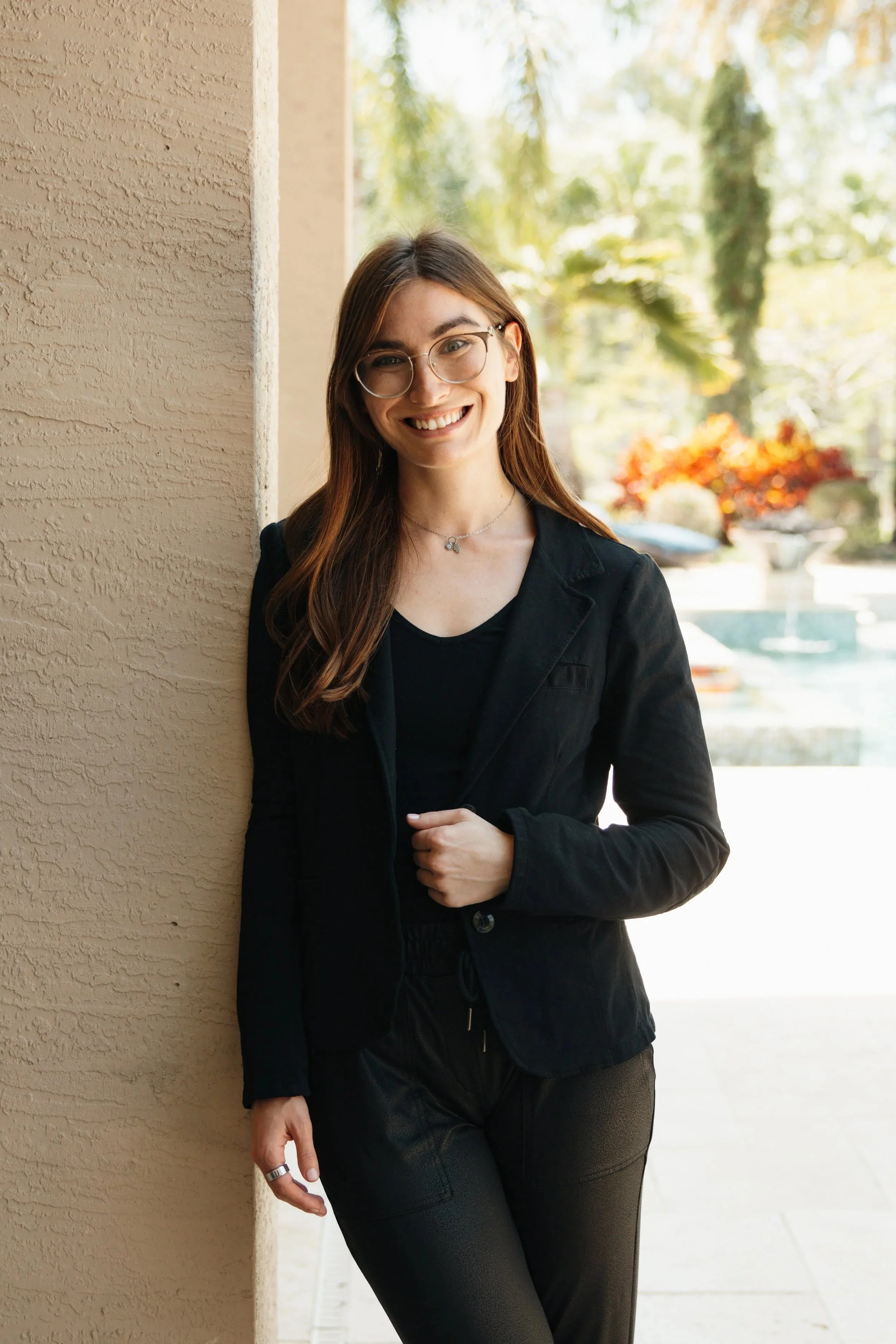 Best Body Recovery winner portrait in a black blazer, leaning against a stone column.