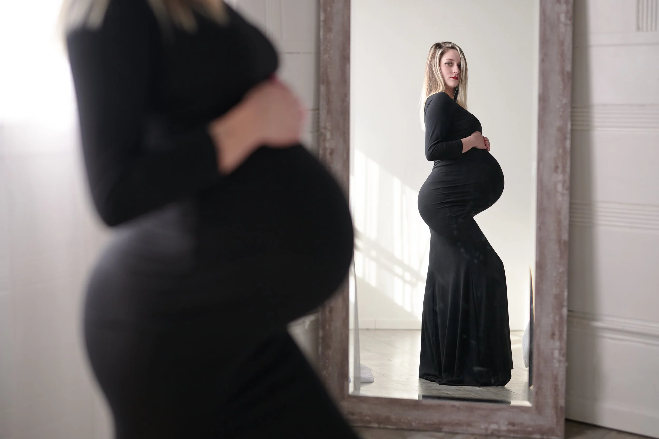 artistic maternity reflection portrait in natural light studio in Denver Colorado