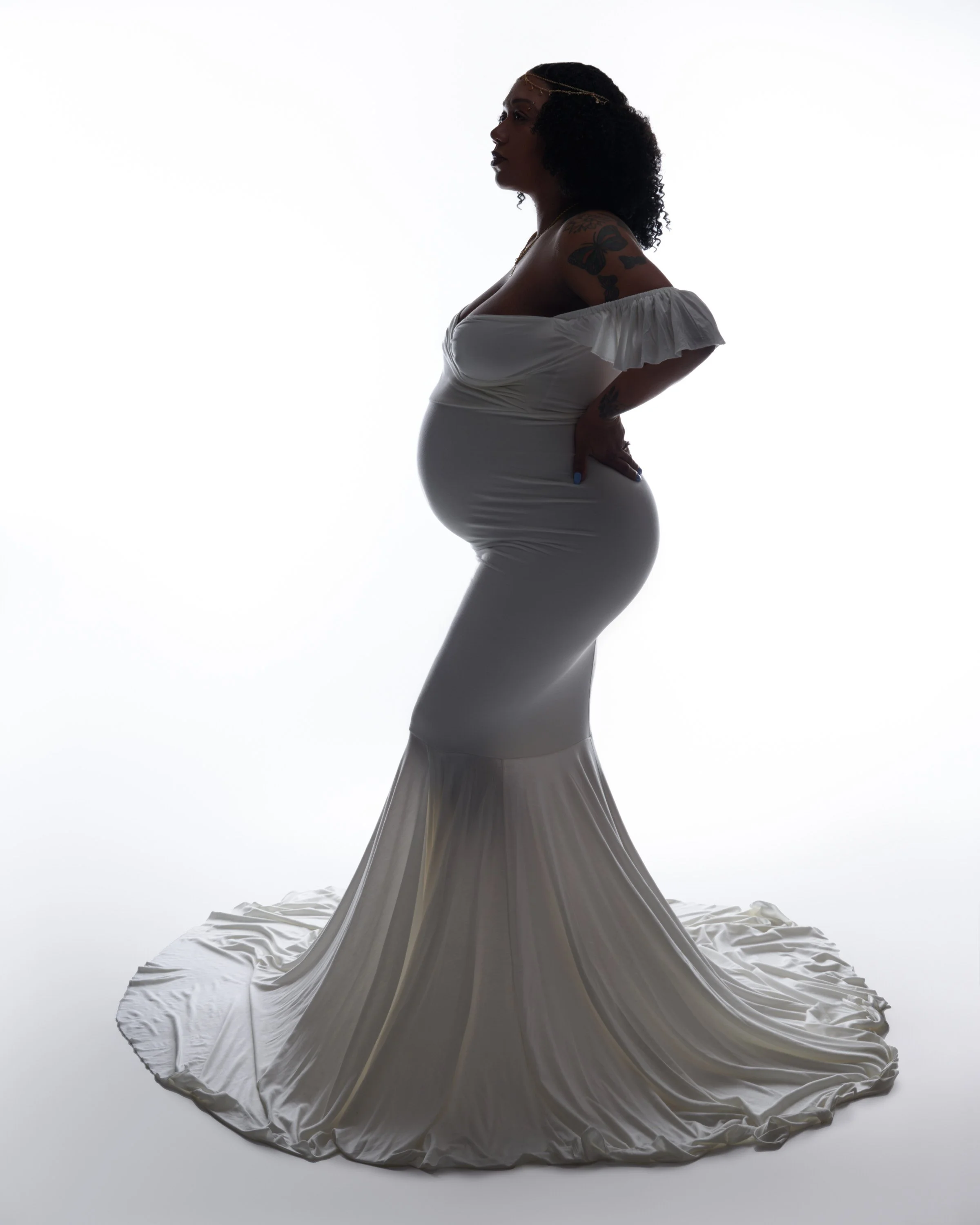 White mermaid gown with a gold hair chain, semi-silhouetted and regal.