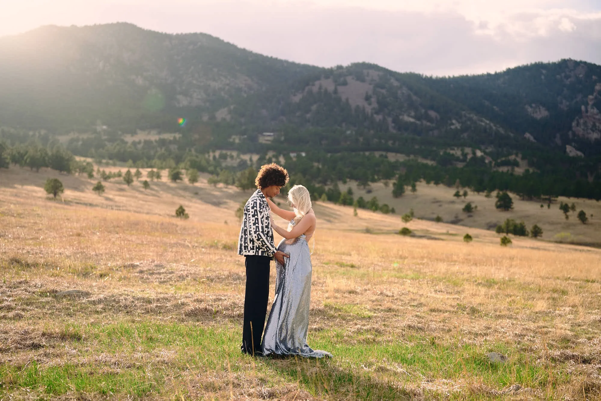 A slow dance in amber evening hills, her sequin gown glinting in the low sun.