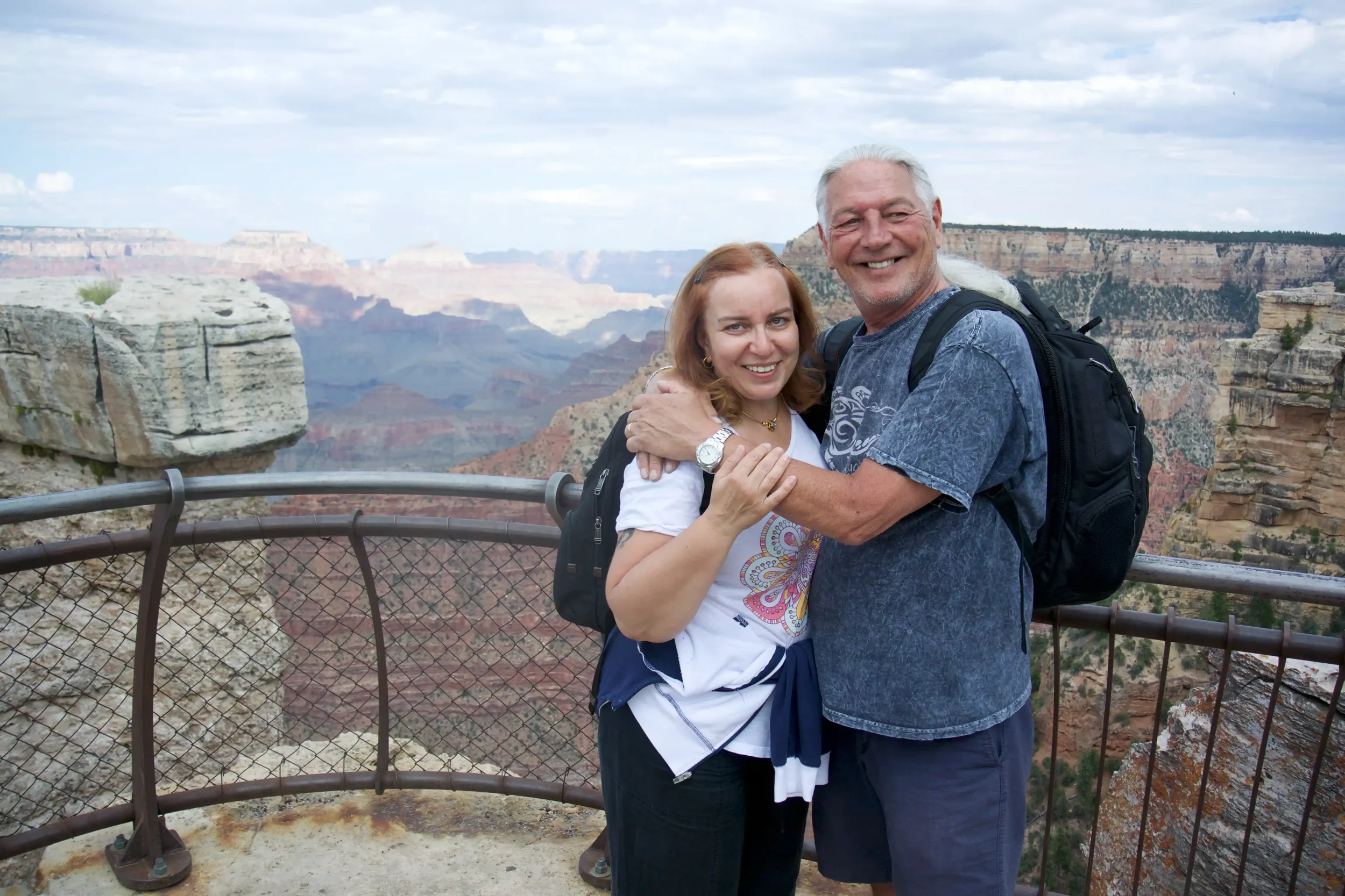 Inga and Randy embrace at a Grand Canyon overlook during the road trip from Seattle to Ohio, layered red cliffs receding into the distance.