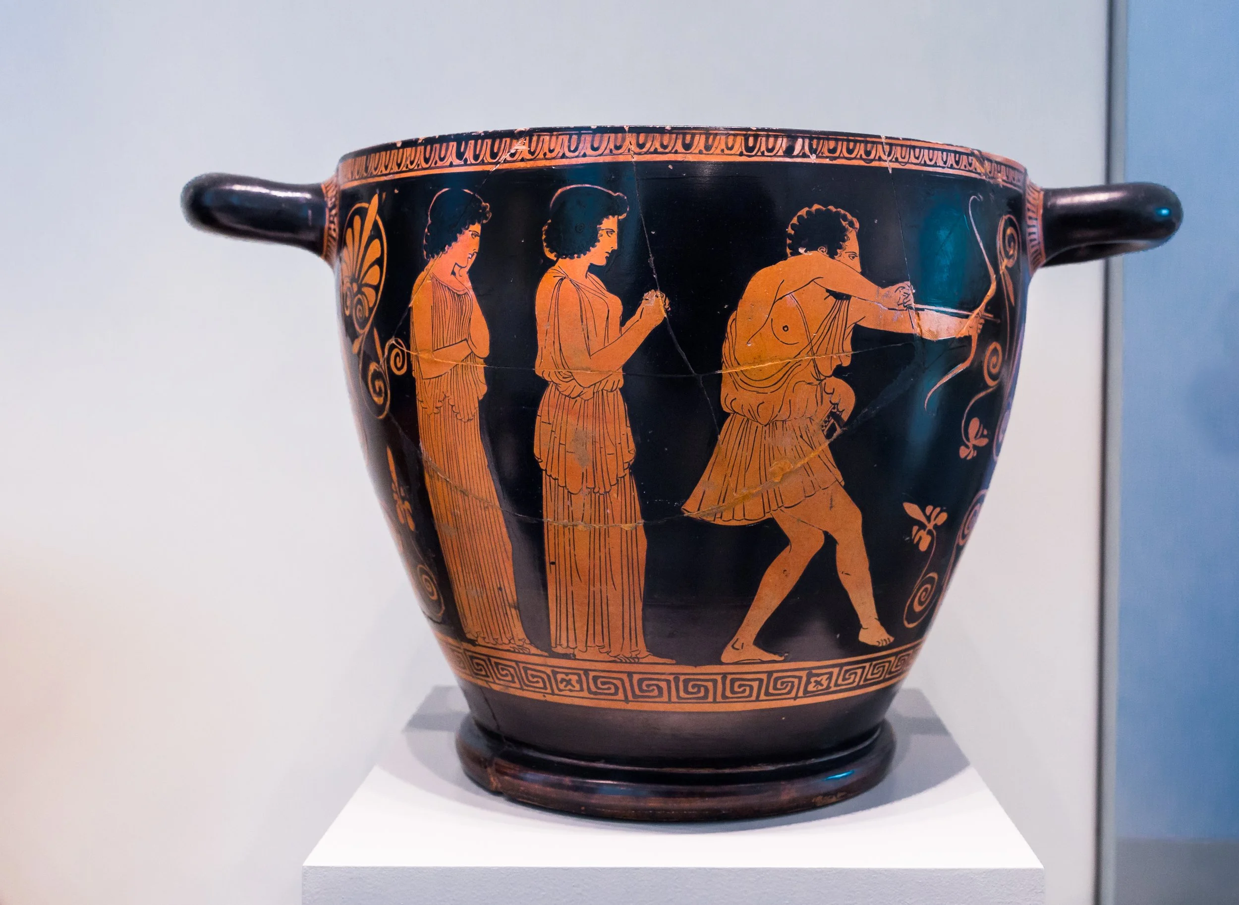 Attic red-figure skyphos by the Penelope Painter, around 440 BCE, showing Odysseus on the right drawing his bow while two women in long gowns stand to his left, in the Altes Museum Berlin.