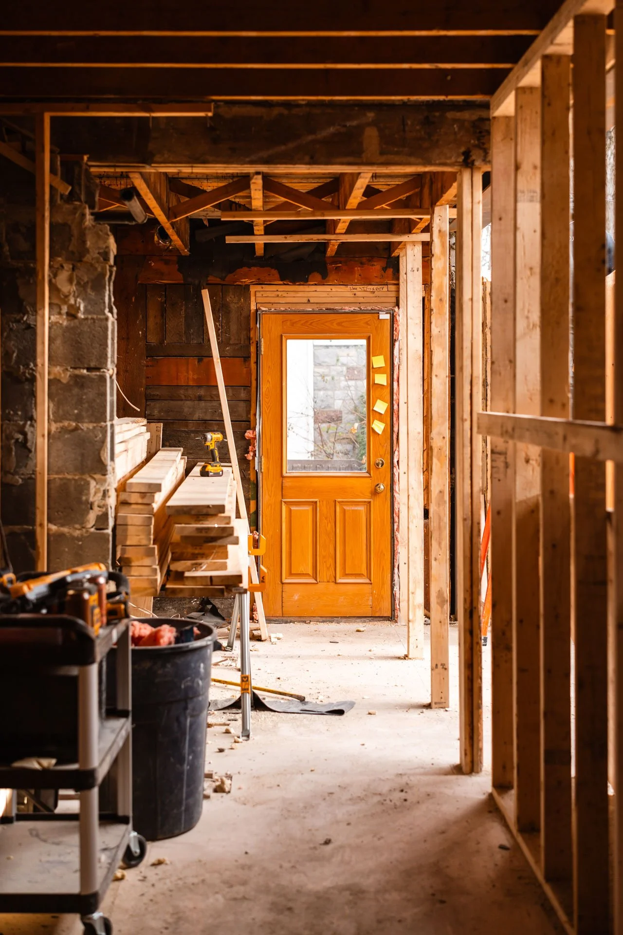 Couloir en cours de rénovation, charpente bois et porte d'entrée, chantier résidentiel