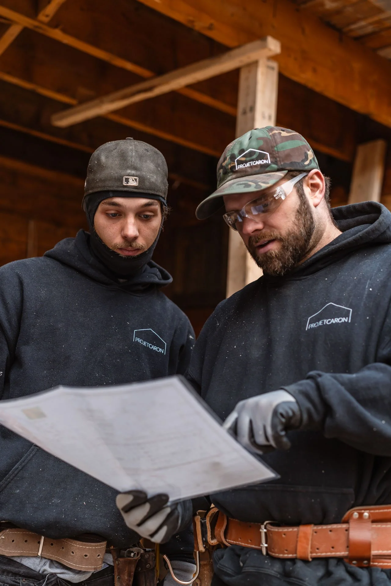 Deux membres de l'équipe Projet Caron consultant les plans de construction