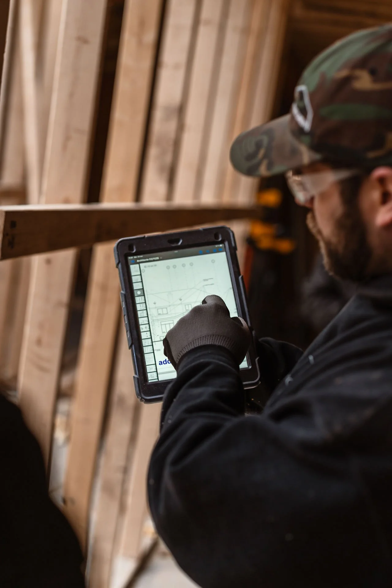 Entrepreneur général consultant ses plans sur tablette sur un chantier