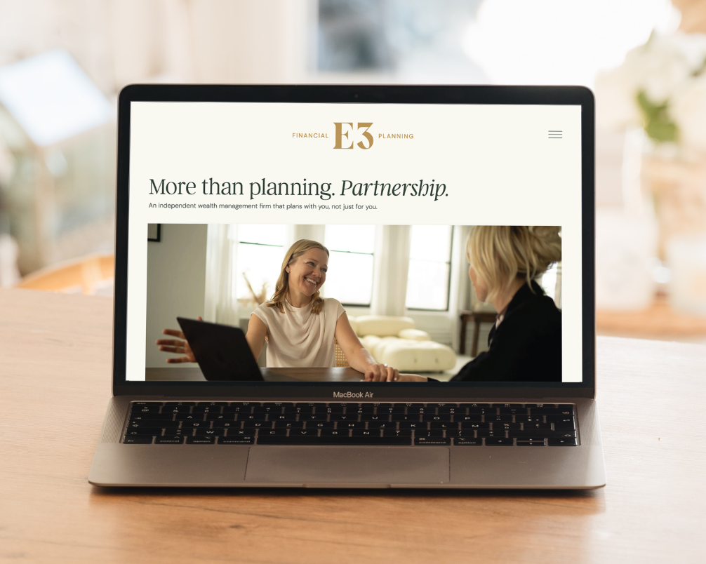 Laptop displaying a website for a financial planning firm with a photo of two women talking.