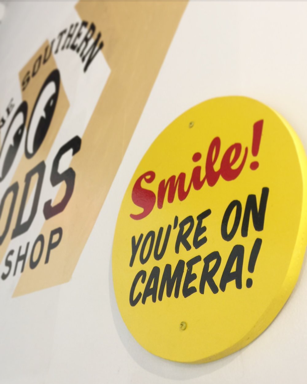 handpainted "smile you're on camera" sign