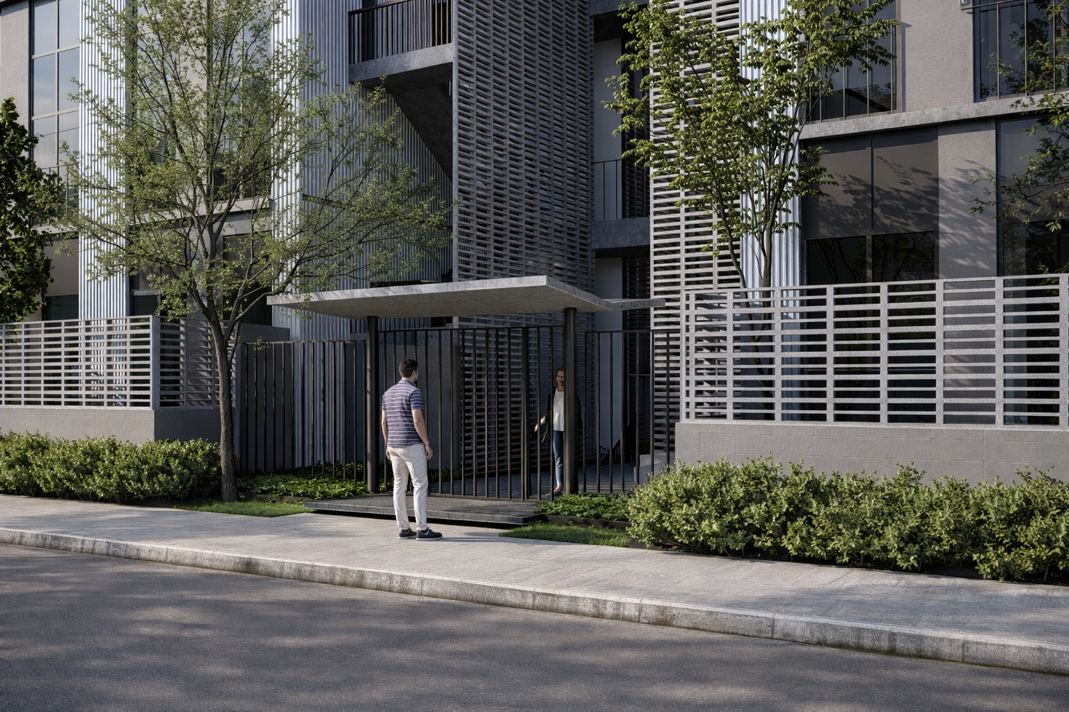 Entrada a un edificio moderno con dos personas conversando en la acera, árboles y arbustos en el entorno.