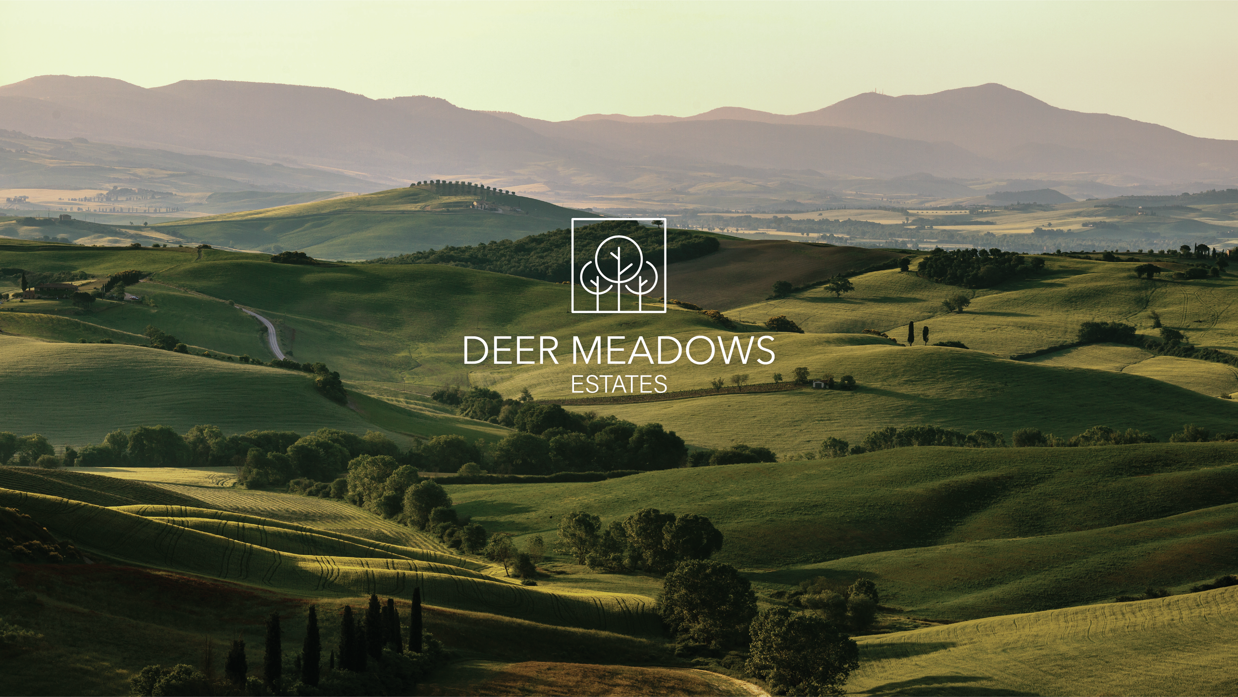 Landscape view of rolling green hills and distant mountains with the text 'Deer Meadows Estates' and an icon of three trees in a square frame.