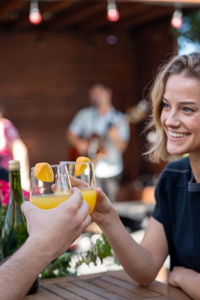 girl drinking cockail with musician in the background