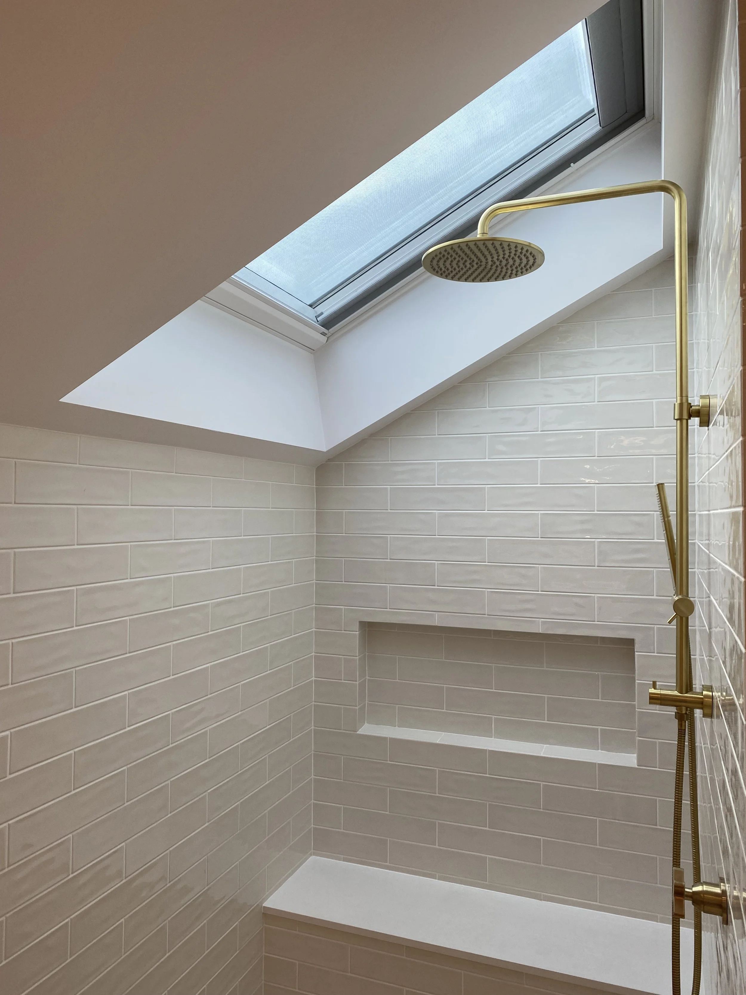 Shower with operable skylight and built in bench. No shower screen to allow for maximum accessibility 