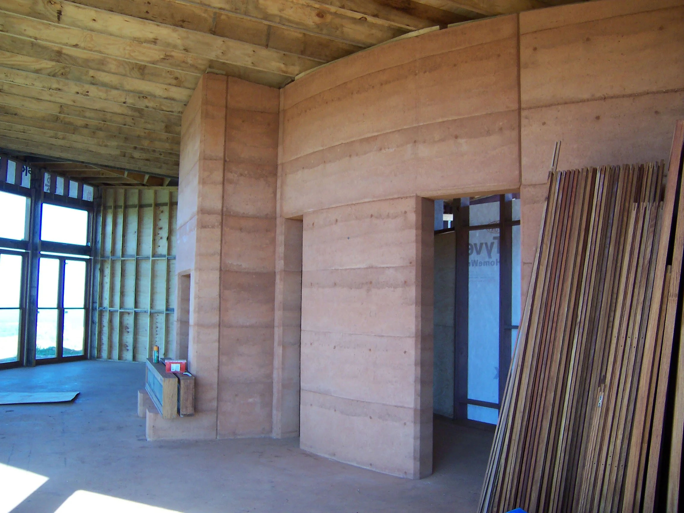 fireplace designed to heat the rammed earth wall which radiates the heat back during the day
