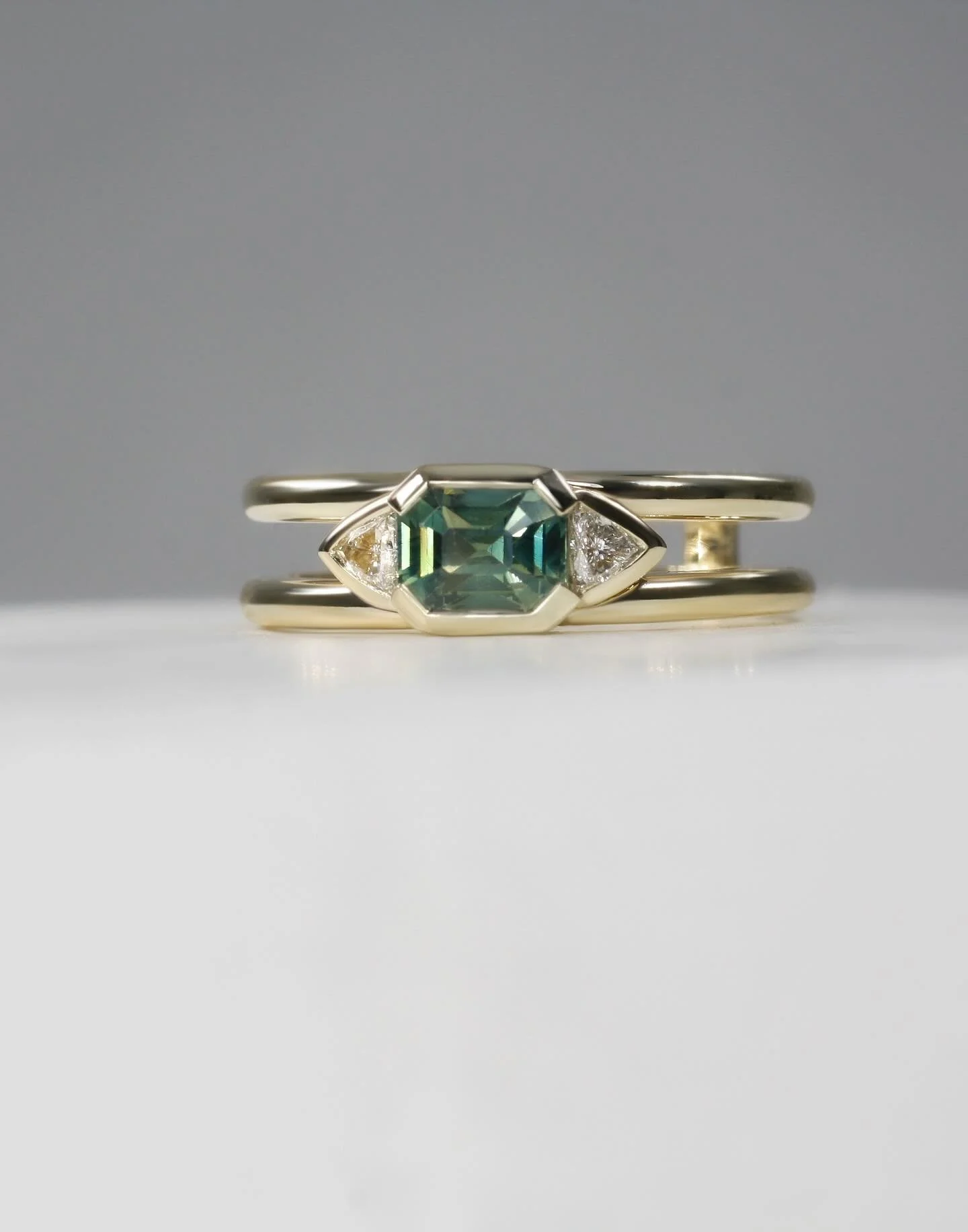 The design journey started on her 30th birthday, and finished in the creation of this stunning bespoke eternity ring. Crafted in 9ct yellow gold, the double-band design showcases a beautiful natural sapphire, further accented by elegant curved trilli