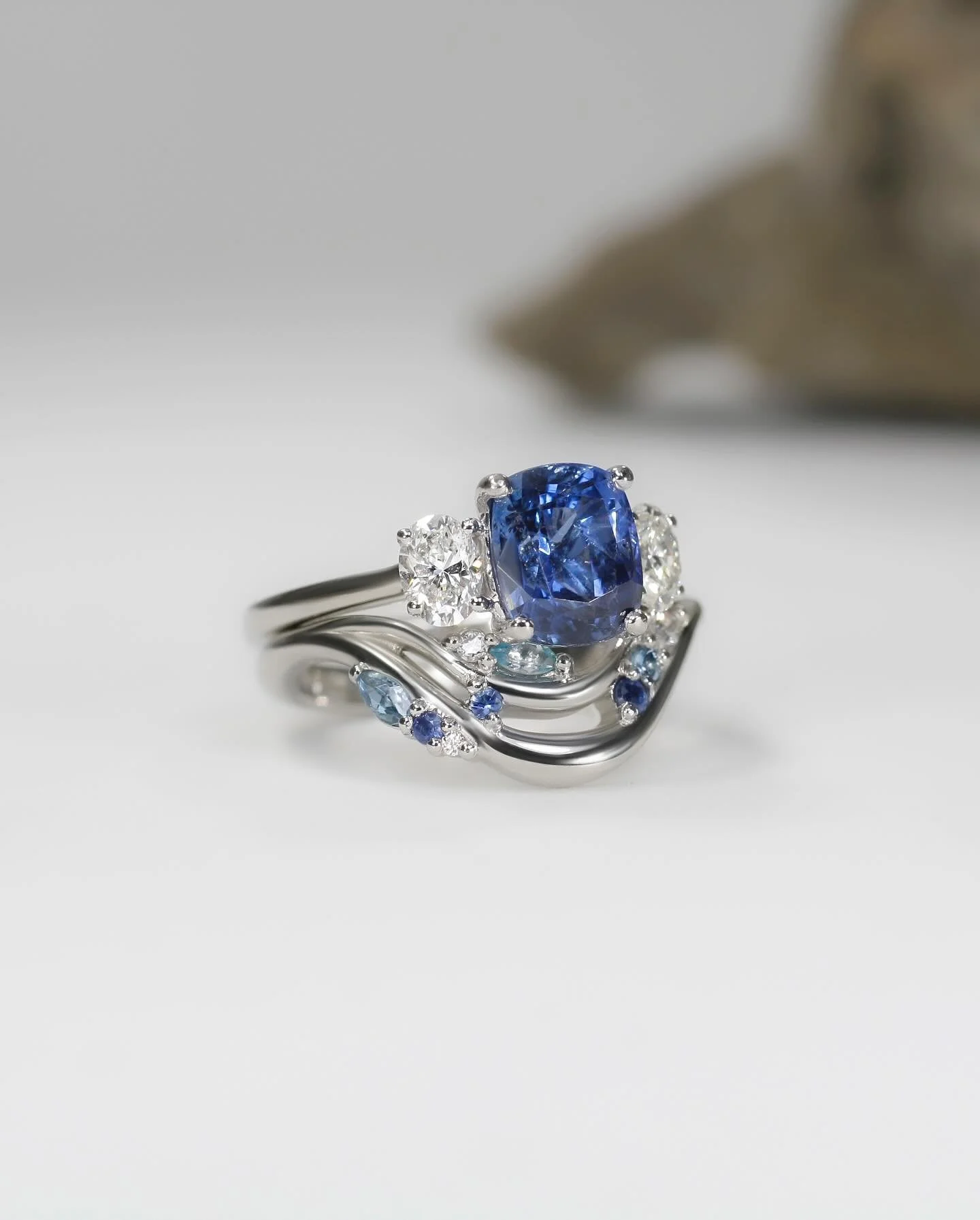 Her wedding band was made specifically to complement her engagement ring, not compete with it. The colours mirror the rich blue of her main stone, with added lighter blue marquise cuts for contrast. Together, they create a cohesive set where each rin