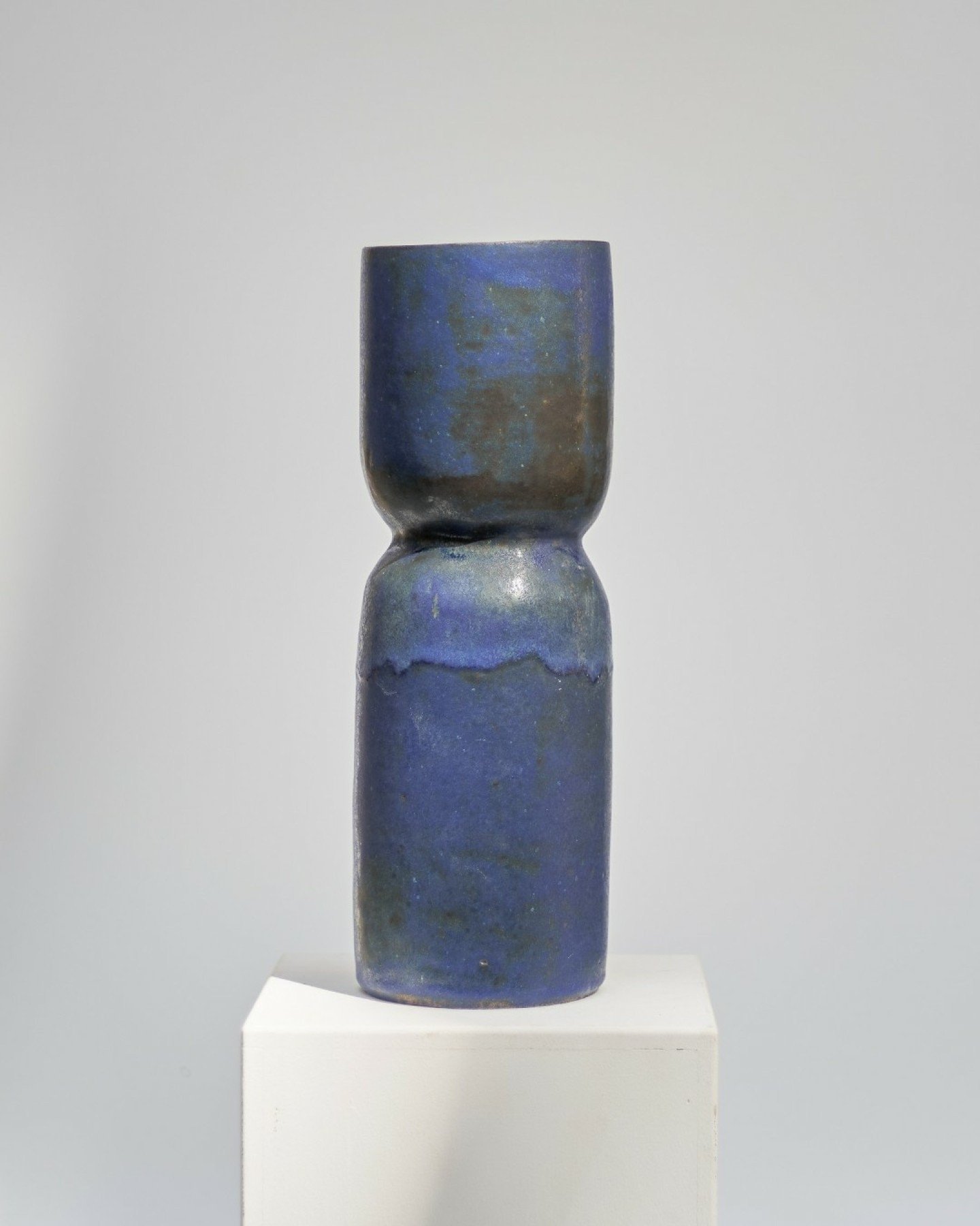 Rich blue meets deep brown, blending in painterly textures. Two distinct forms come together to create one elegant silhouette&mdash;a tall, refined vase. Minimal yet expressive, it embodies simplicity with depth.