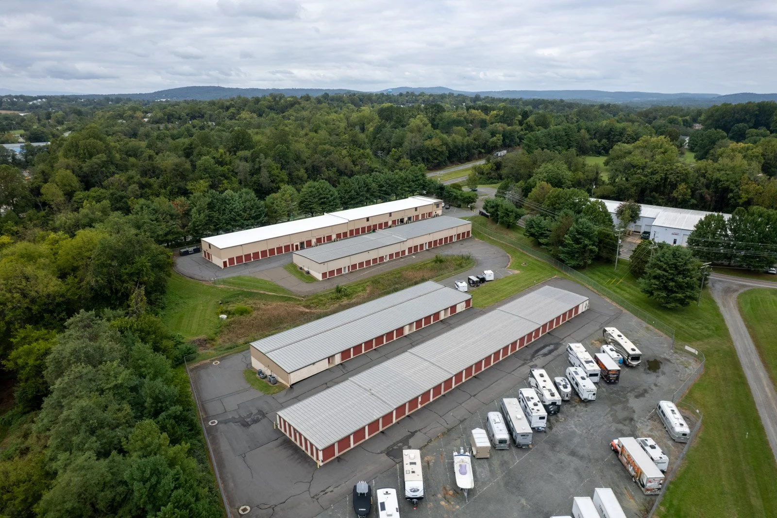 Wide aerial view of Warrenton Mini Storage, showing the white TPO retrofit roof, surrounding storage buildings, and RV parking.