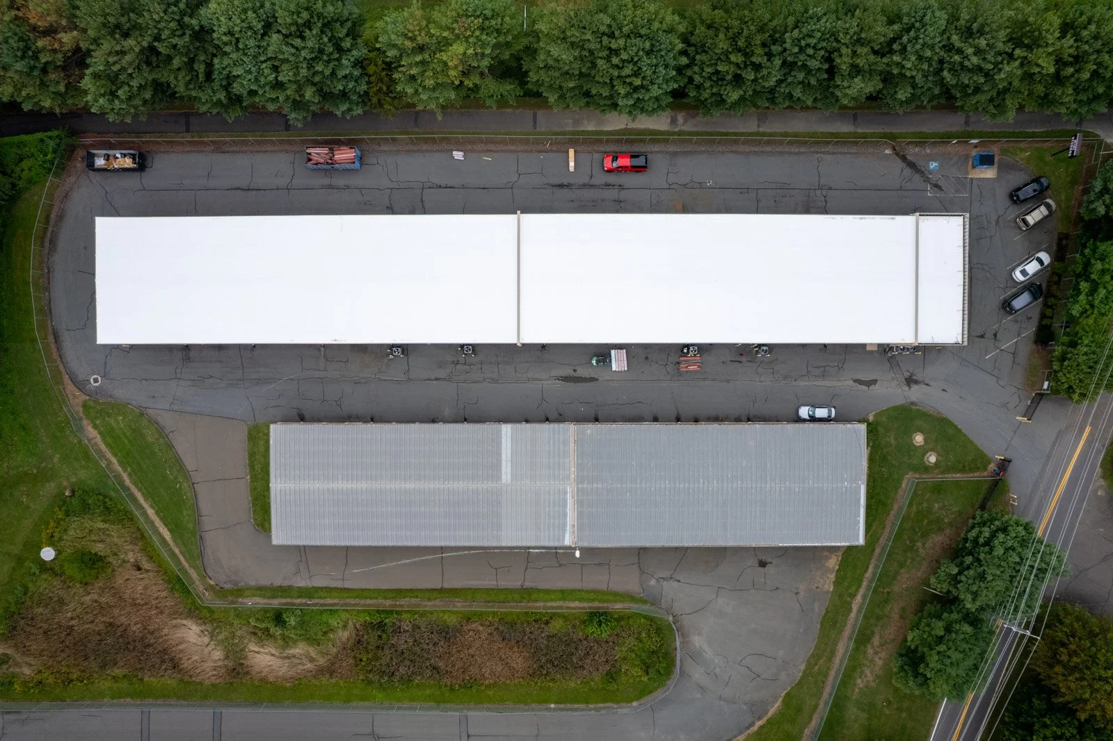 Overhead view of the full white TPO roof beside a gray metal-roofed storage building at Warrenton Mini Storage in Virginia.