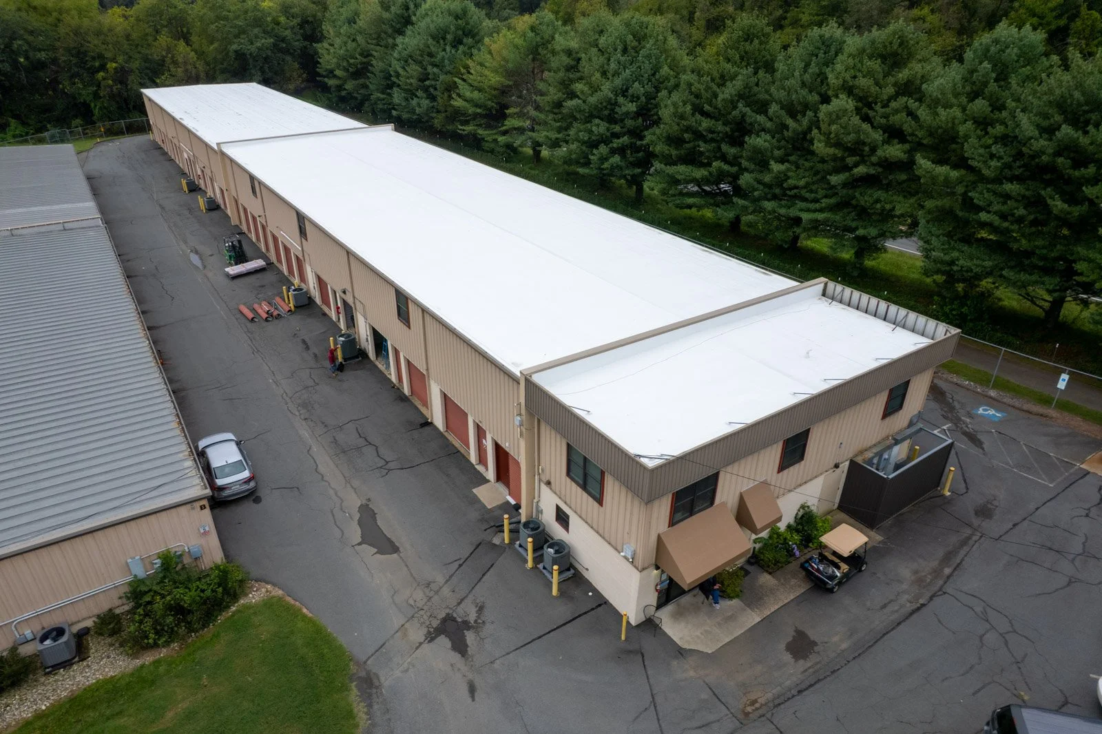 Angled aerial view of the white TPO retrofit roof above storage units and the office at Warrenton Mini Storage in Virginia.