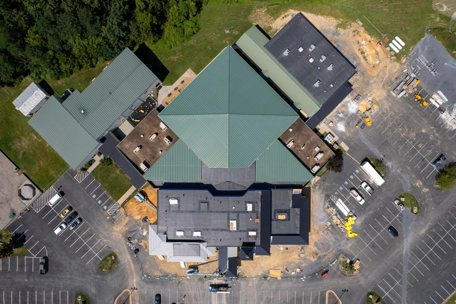 Aerial view of workers installing black metal roofing on the entrance canopy at Covenant Presbyterian Church in Harrisonburg, VA.