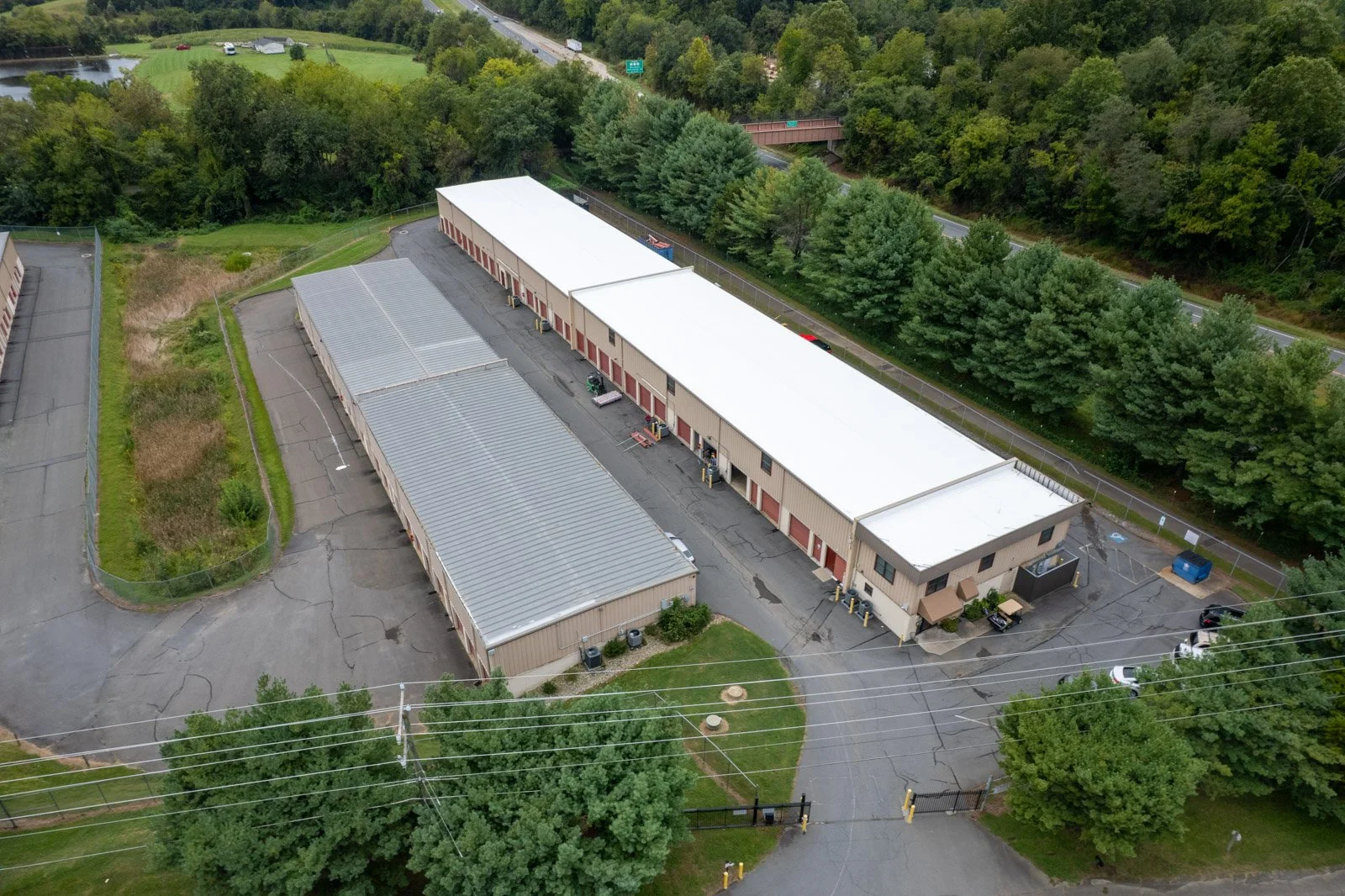 Aerial view of neighboring storage buildings with white TPO and gray metal roofs at Warrenton Mini Storage in Warrenton, VA.