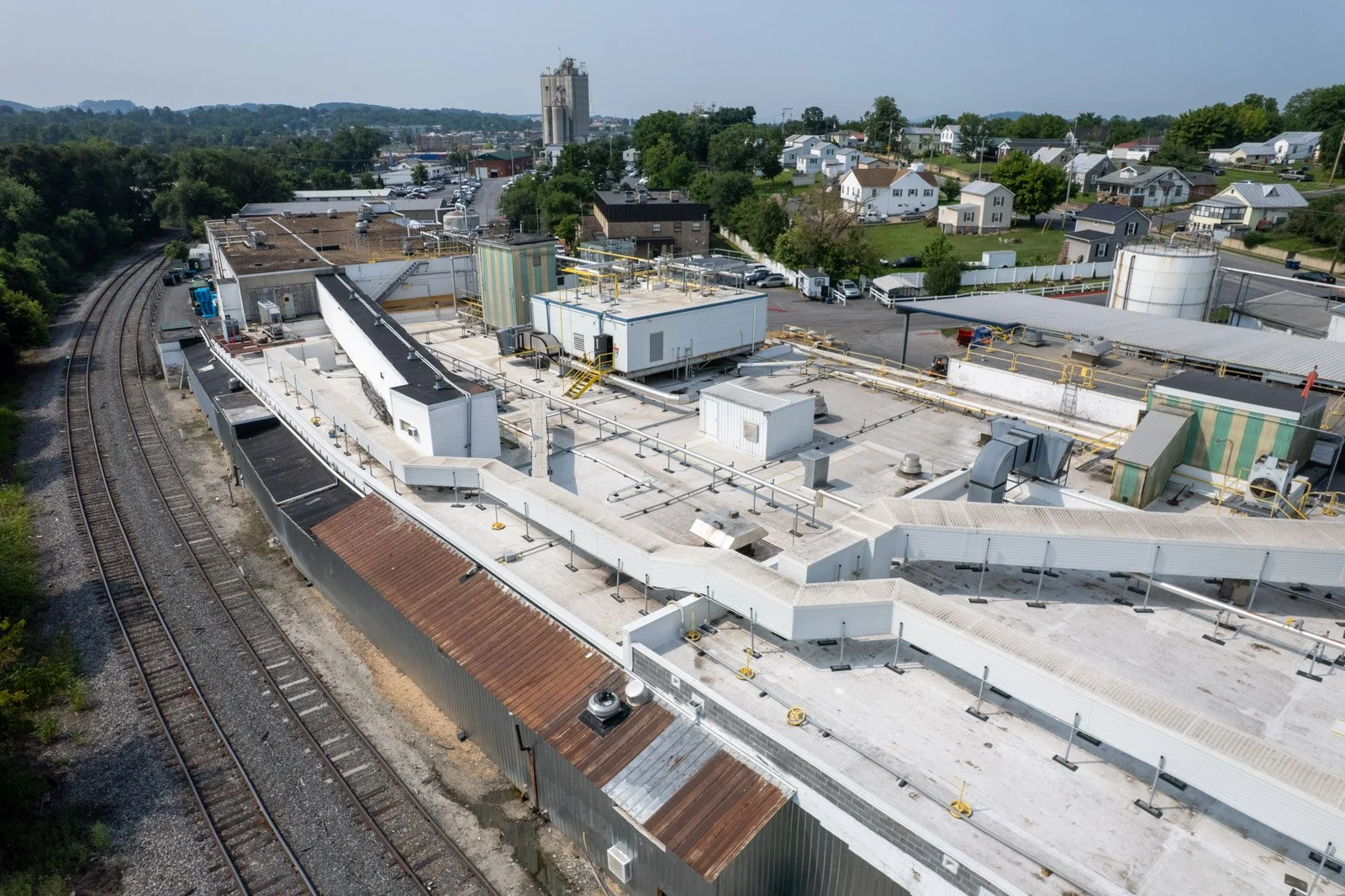 Aerial view of the Farmer Focus facility’s white commercial roofing system alongside rooftop equipment and rail lines.