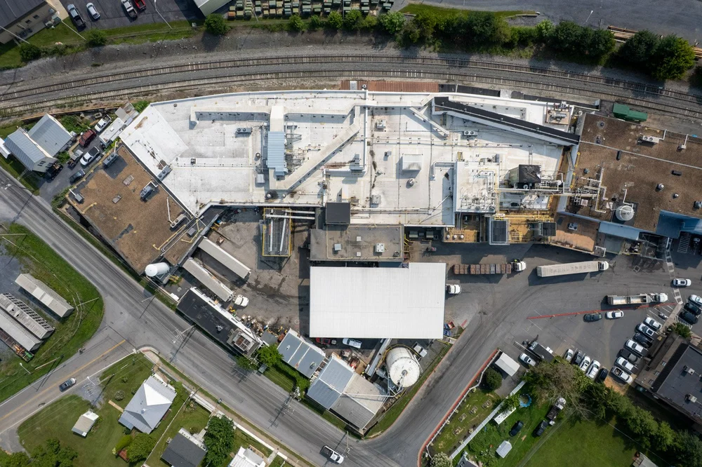 Top-down drone view of the Farmer Focus commercial roof replacement and surrounding facility.