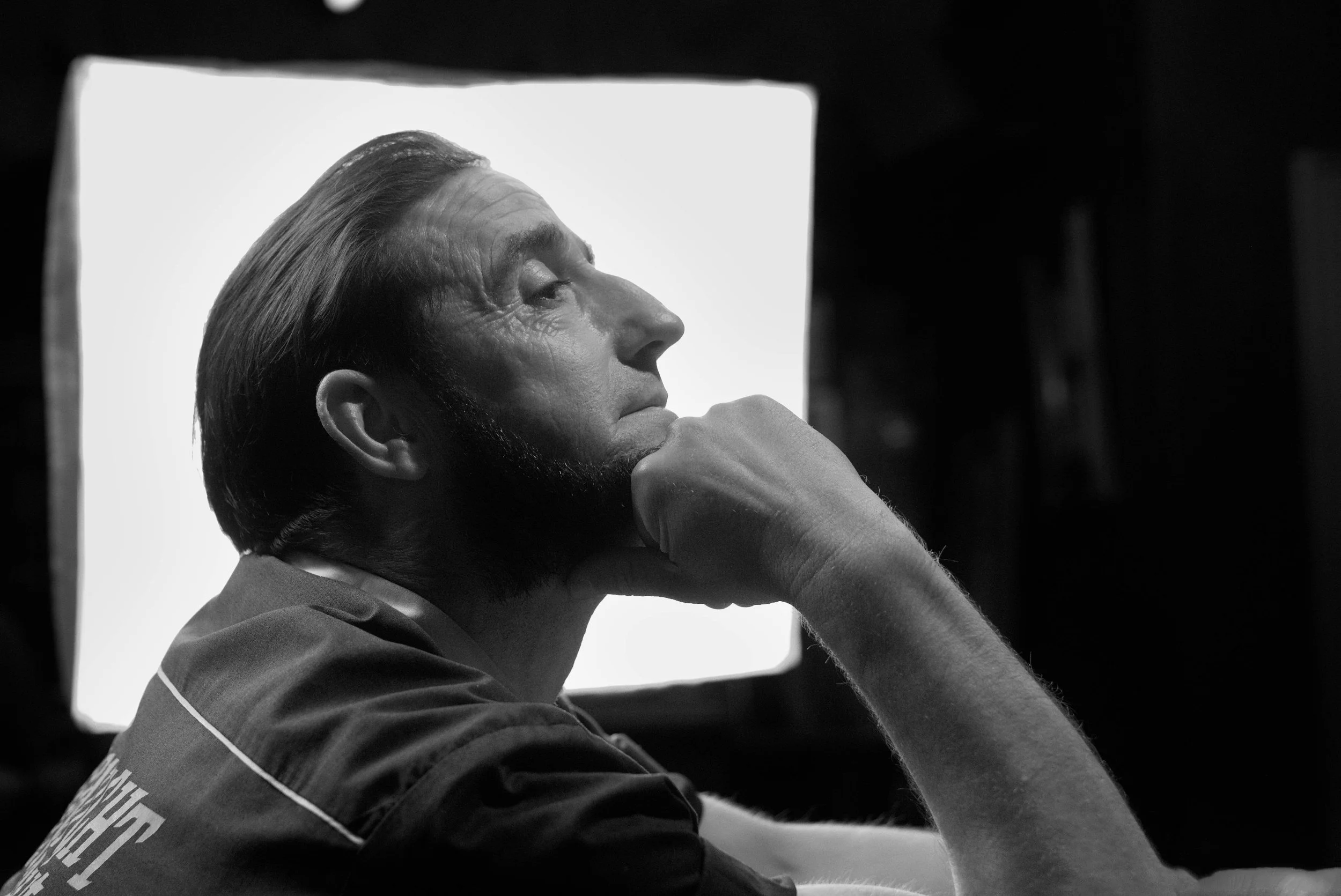 Black and white profile of the lead actor lit by a bright softbox.