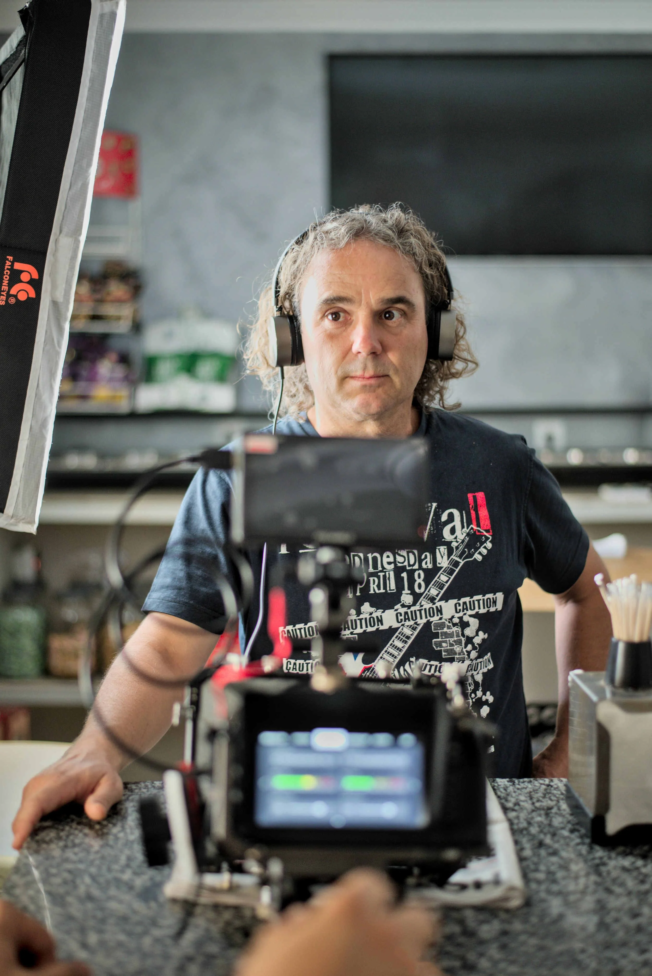 Sound mixer wearing headphones, concentrating on the monitor in a bar or café.