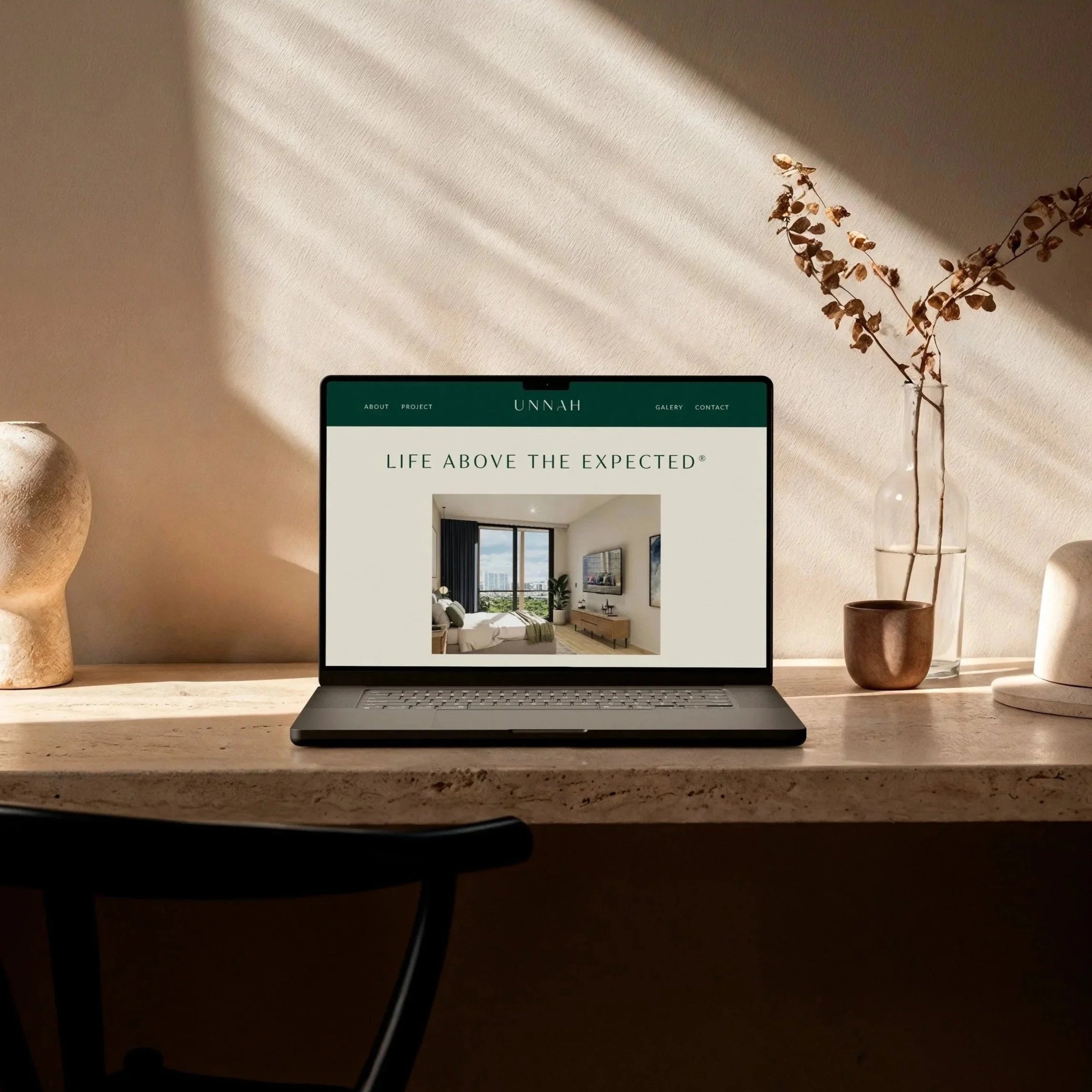 Smartphone on textured surface displaying a furniture website with a living room image and the text 'ELEVATED DESIGNS FOR ELEVATED LIVING'.