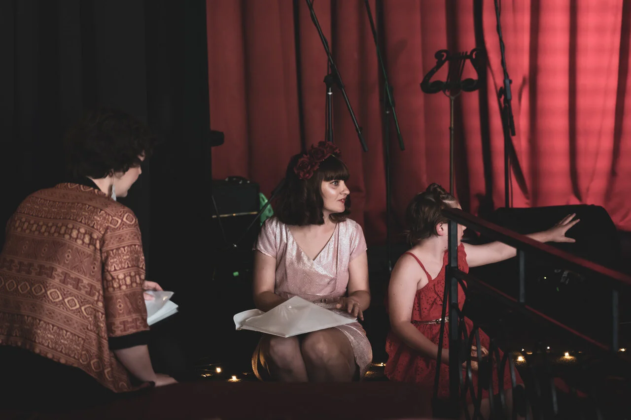 Sitting side of stage with her daughter.