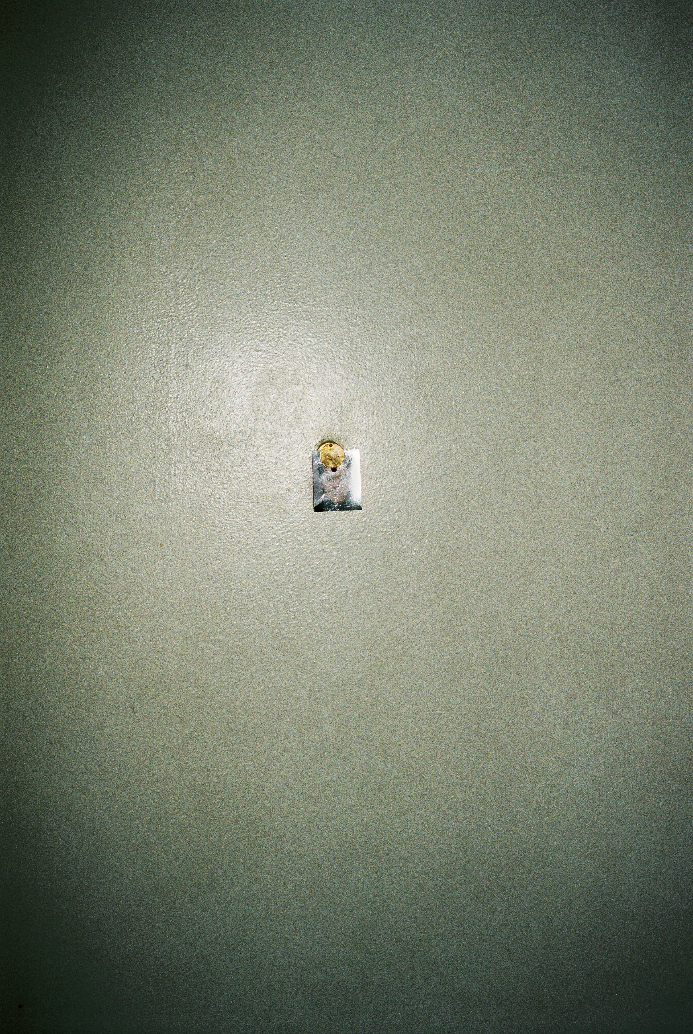 Passport picture attached to the peephole of an apartment door