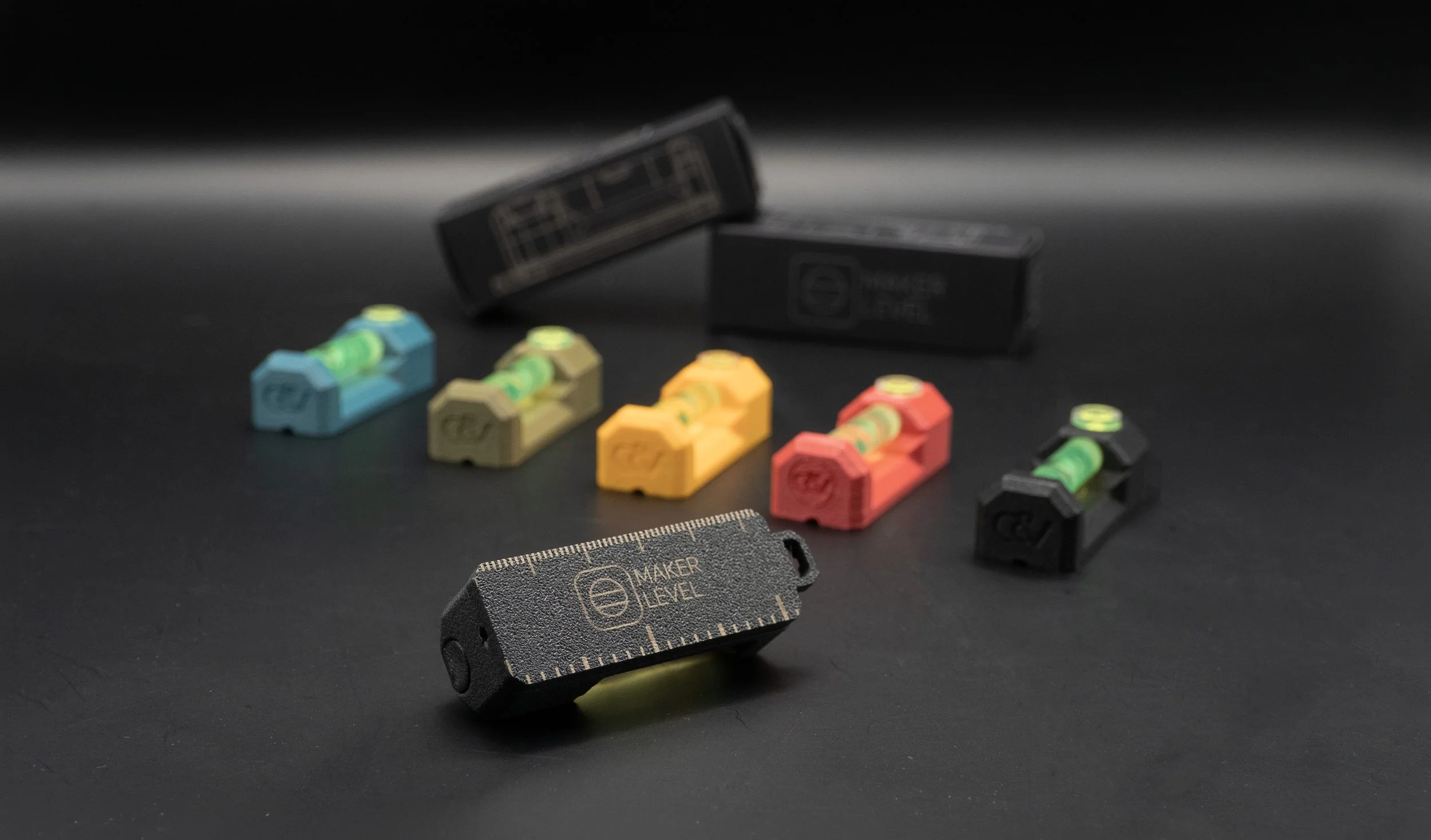 Colorful Maker Levels arranged in a row, with packaging in the background on a dark surface.