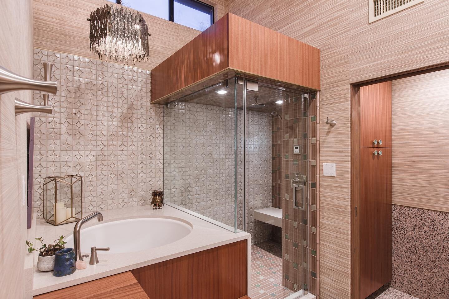 A closer look at the #steamshower and #soakingtub 
The toilet room brings the flooring up the wall to act as a wainscoting for cleanliness, and we slipped in a linen closet as well. The wallpaper is a grass woven product that is both retro and contem