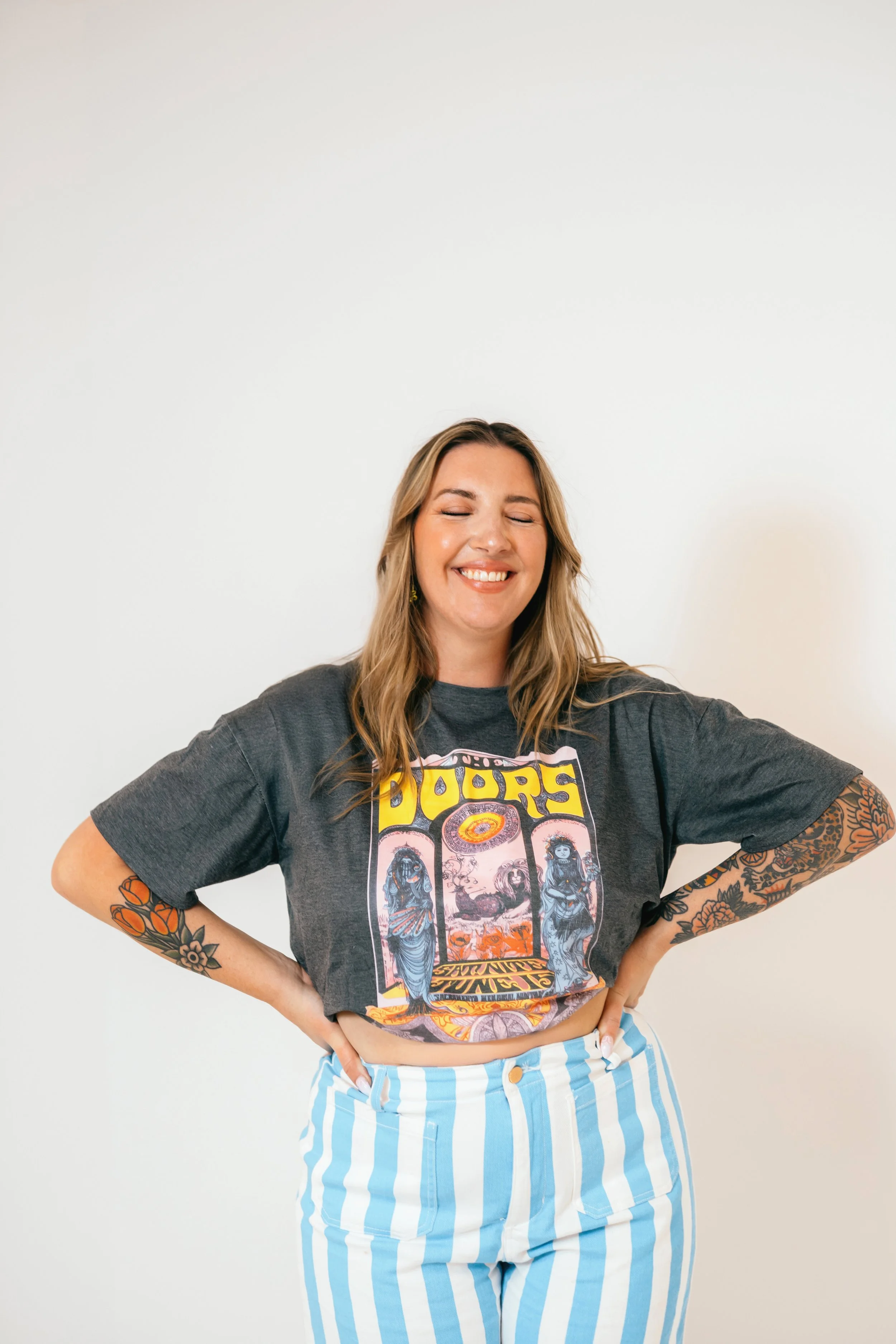 Southern California cookie decorator and home baker holding custom sugar cookie with playful expression during a colorful branding portrait photoshoot. Lifestyle marketing photography highlighting creative small business owner personality, captured b