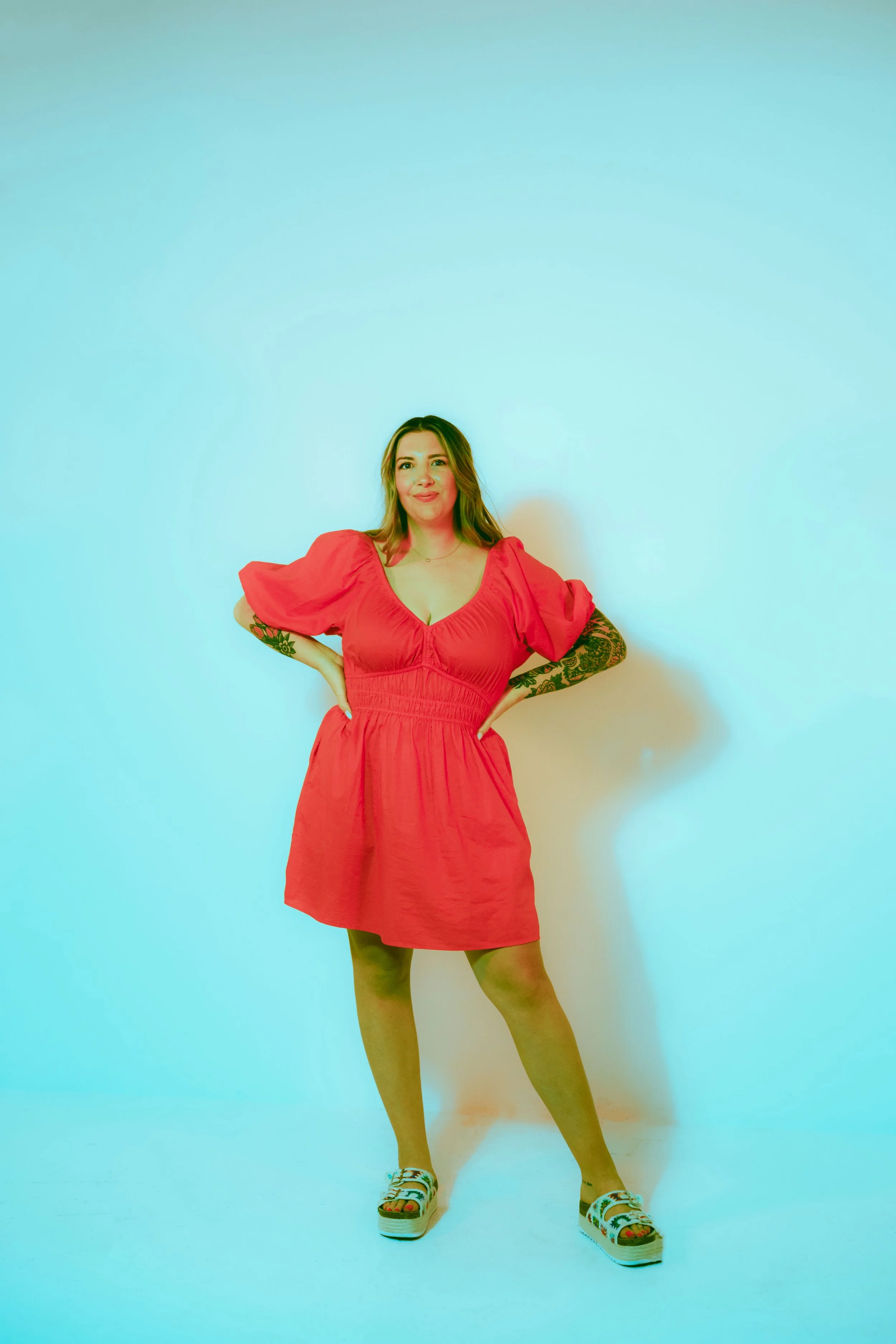 Colorful studio branding portrait of Southern California cookie decorator wearing bright dress against modern backdrop. Vibrant small business photography for creative entrepreneur and home bakery brand, photographed by Southern California lifestyle 