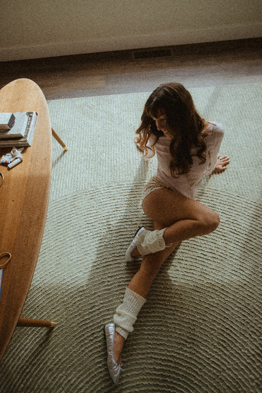 Chloe Montoya sitting on groudn posing in her home in San clemente, CA. Photo taken by southern california lifestyle creative portrait photographer- KElsie Carlson. Model sitting by window, posing inspiration, girly fem outfit inspiration