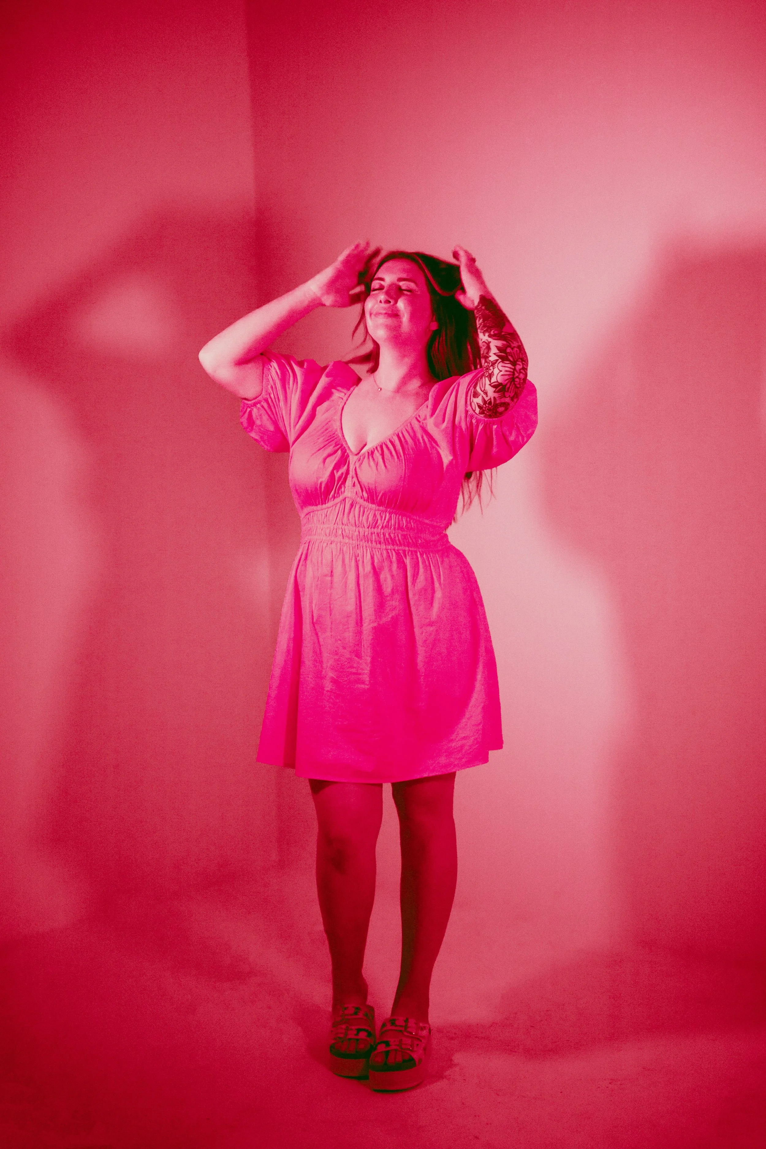 Orange County home baker posing in bright pink dress during studio branding photoshoot for cookie decorating business. Modern small business branding photography with bold color lighting and confident female entrepreneur energy. Photographed by South