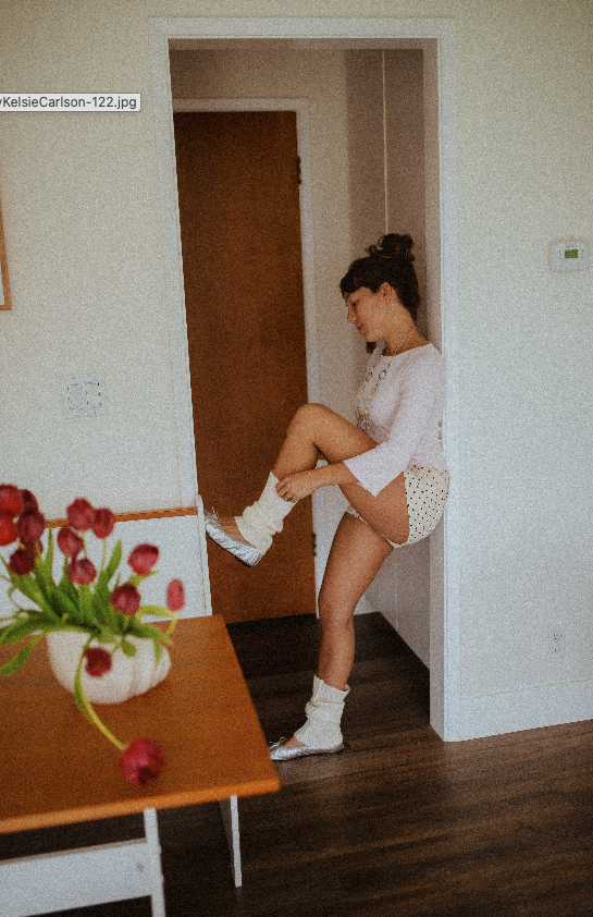 Chloe Montoya standing in her doorway in her home in orange county, CA. Creative lifestyle portrait photoshoot- standing ina. fun and unique way in home photoshoot, Wearing, Ballet flats, leg warmers and micro shorts. POsing inspiration for creative 