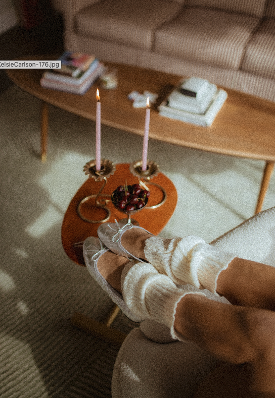 chrome glass full of dark cherries sitting on a red striped couch, Aestehtic cherry lifestyle photoshoot, Chloe Monotoya in her home in San Clemente, Cute girly aesthetic, pink candlesticks, white bubble chair, leg warmers, micro shorts and ballet fl