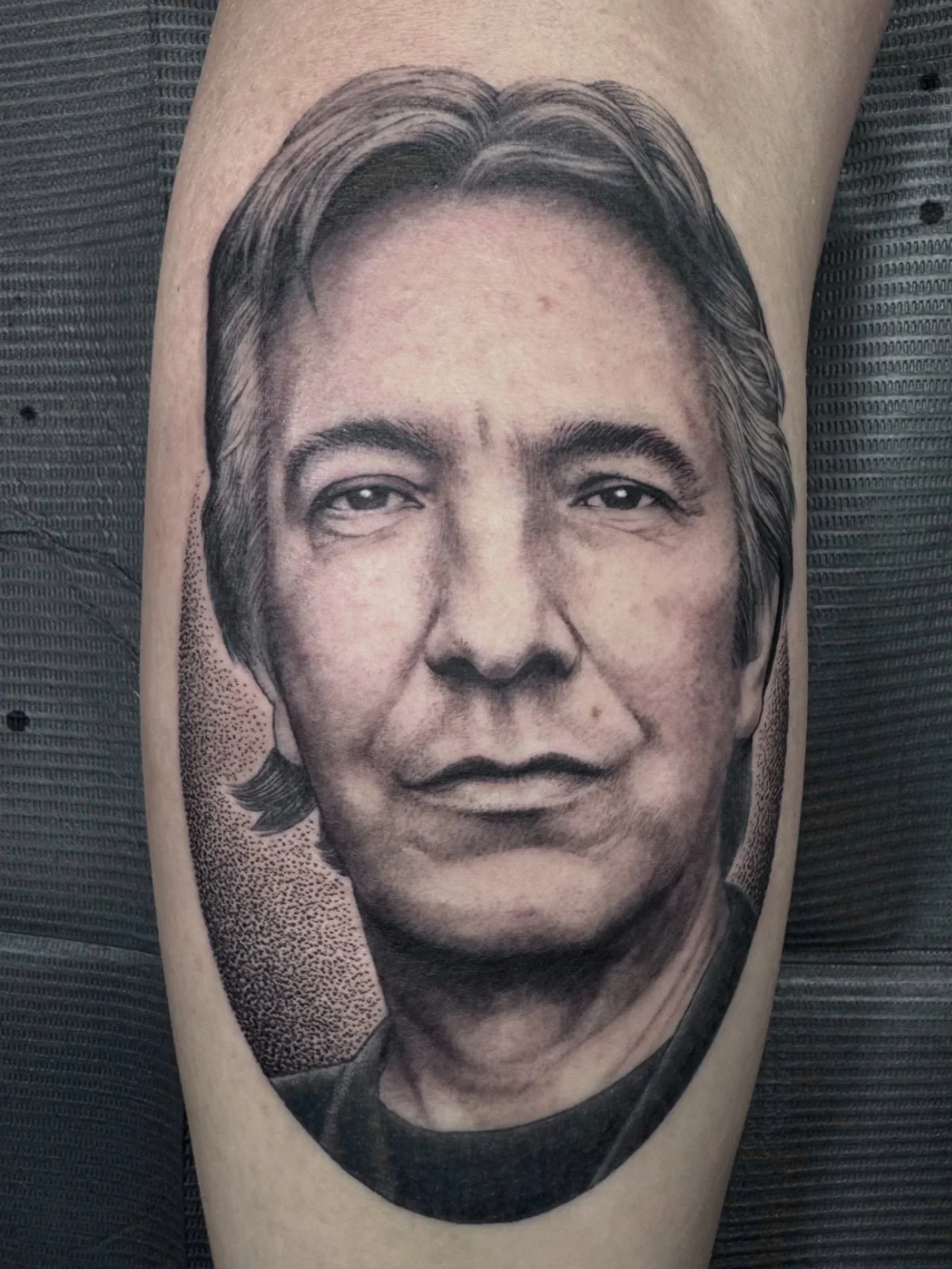 A fine line black and grey celebrity tattoo portrait of Alan Rickman, created by Seattle tattoo artist Eli Bischof.