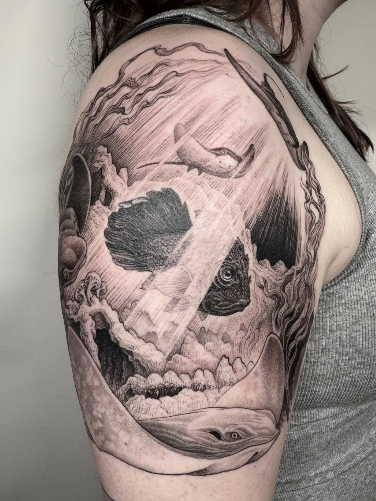 Fine line black and grey skull illusion tattoo consisting of stingrays and marine life, made by Seattle tattoo artist Eli Bischof