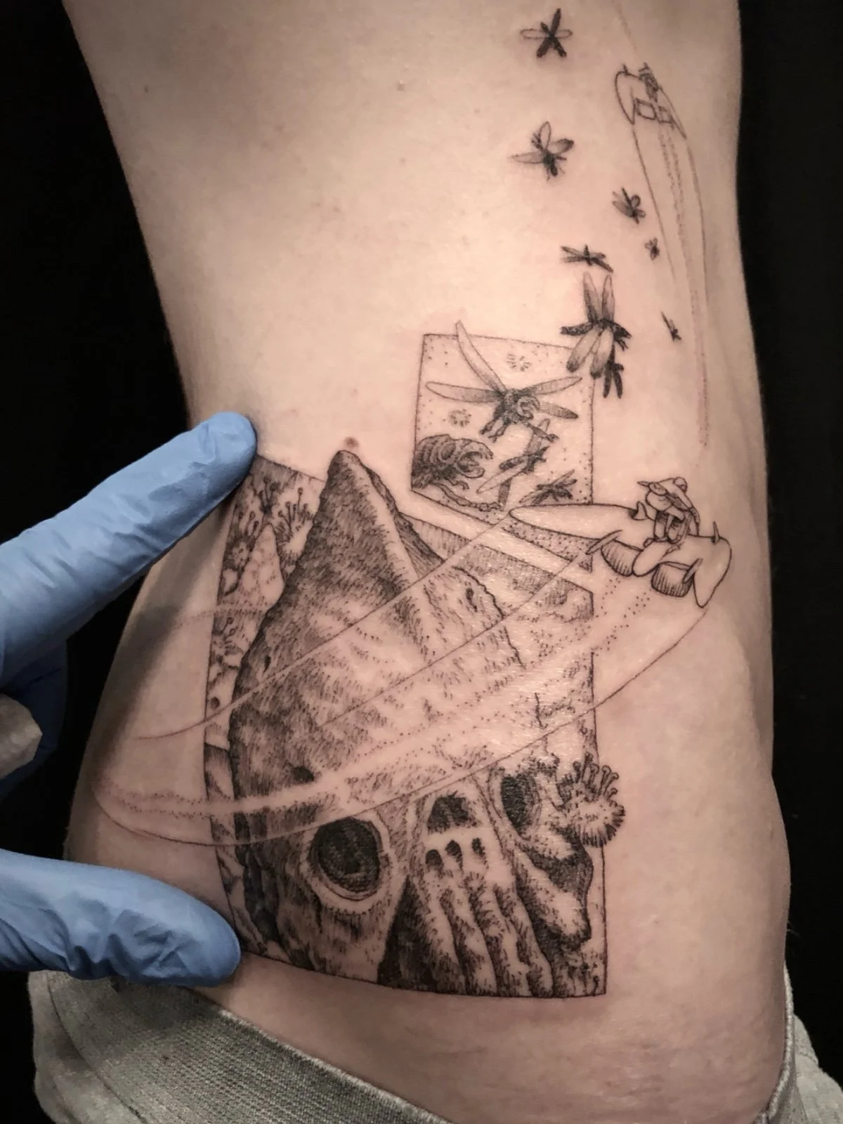 A detail photo of a fine line and black and grey tattoo of art from Nausicaä of the Valley of the Wind, created by Seattle tattoo artist Eli Bischof.