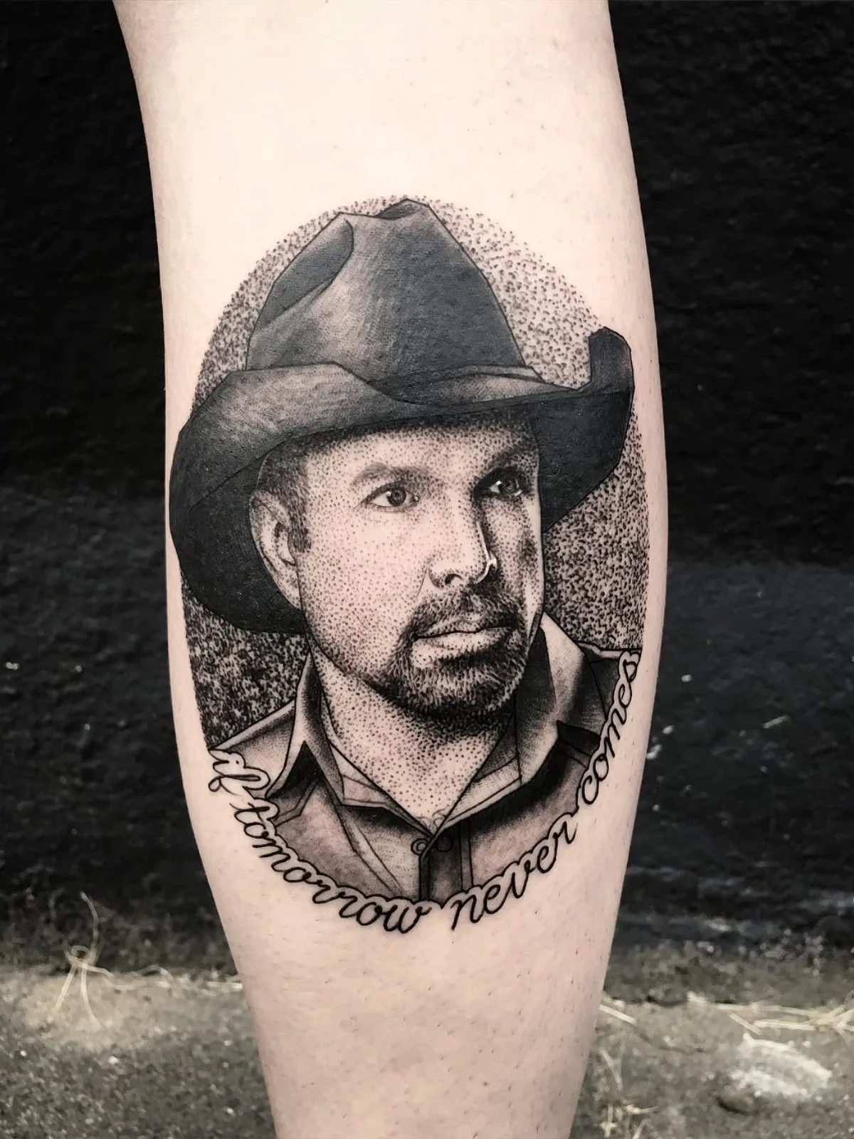 Stipple, dotwork, and black and grey portrait tattoo of Garth Brooks wearing a cowboy hat, created by Seattle tattoo artist Eli Bischof.