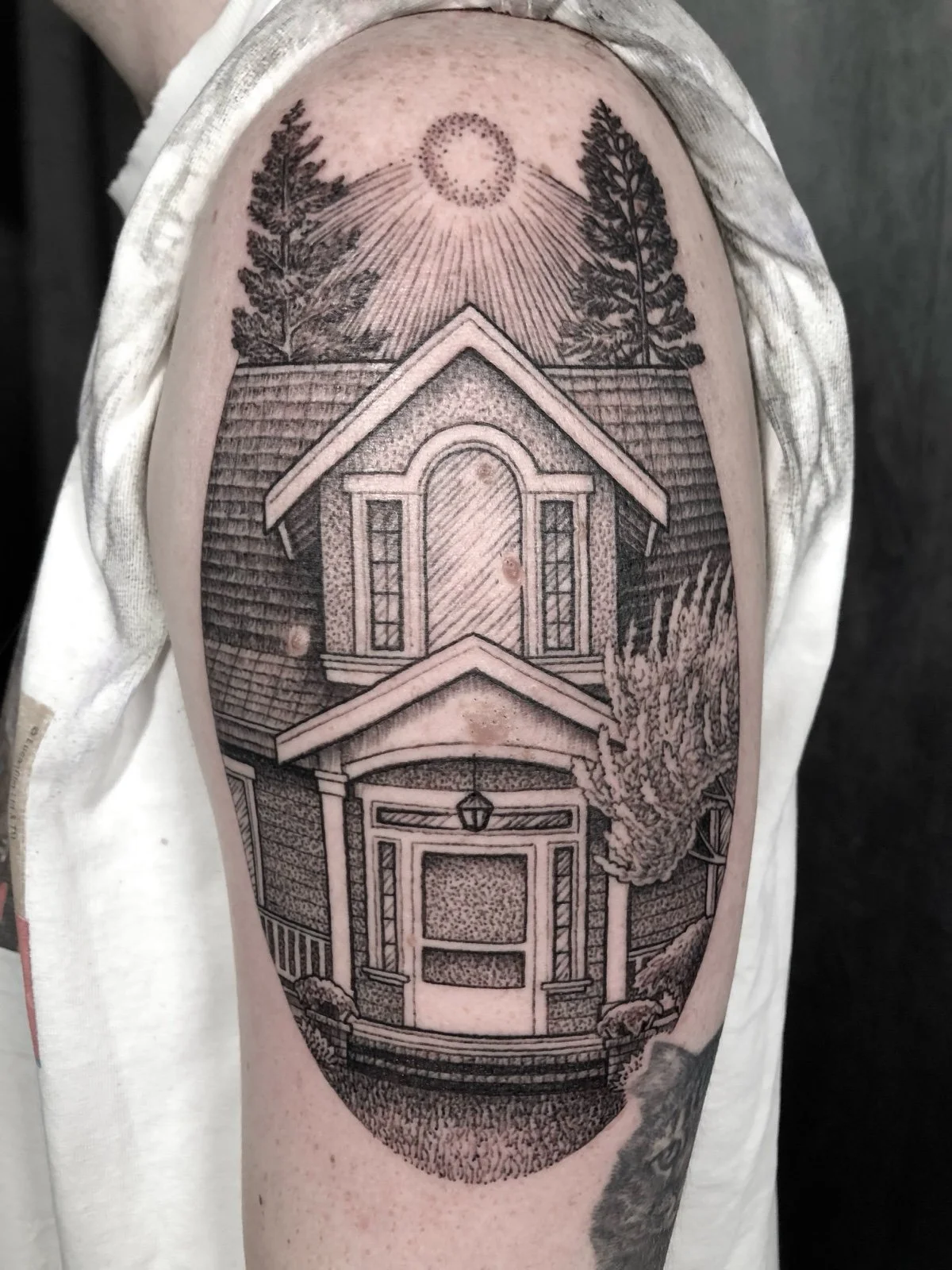 A fine line and black and grey tattoo of a childhood home, created by Seattle tattoo artist Eli Bischof.