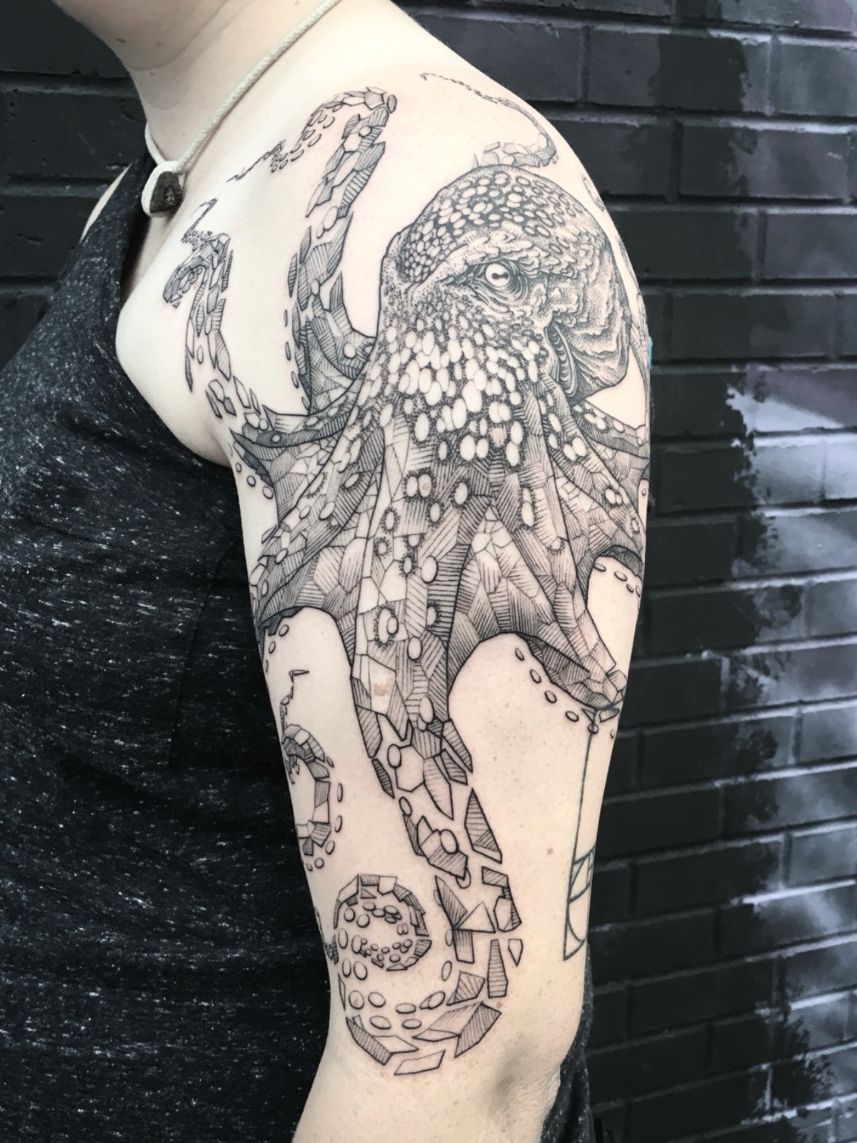 Fine line black and grey octopus tattoo with geometric elements, created by Seattle tattoo artist Eli Bischof.